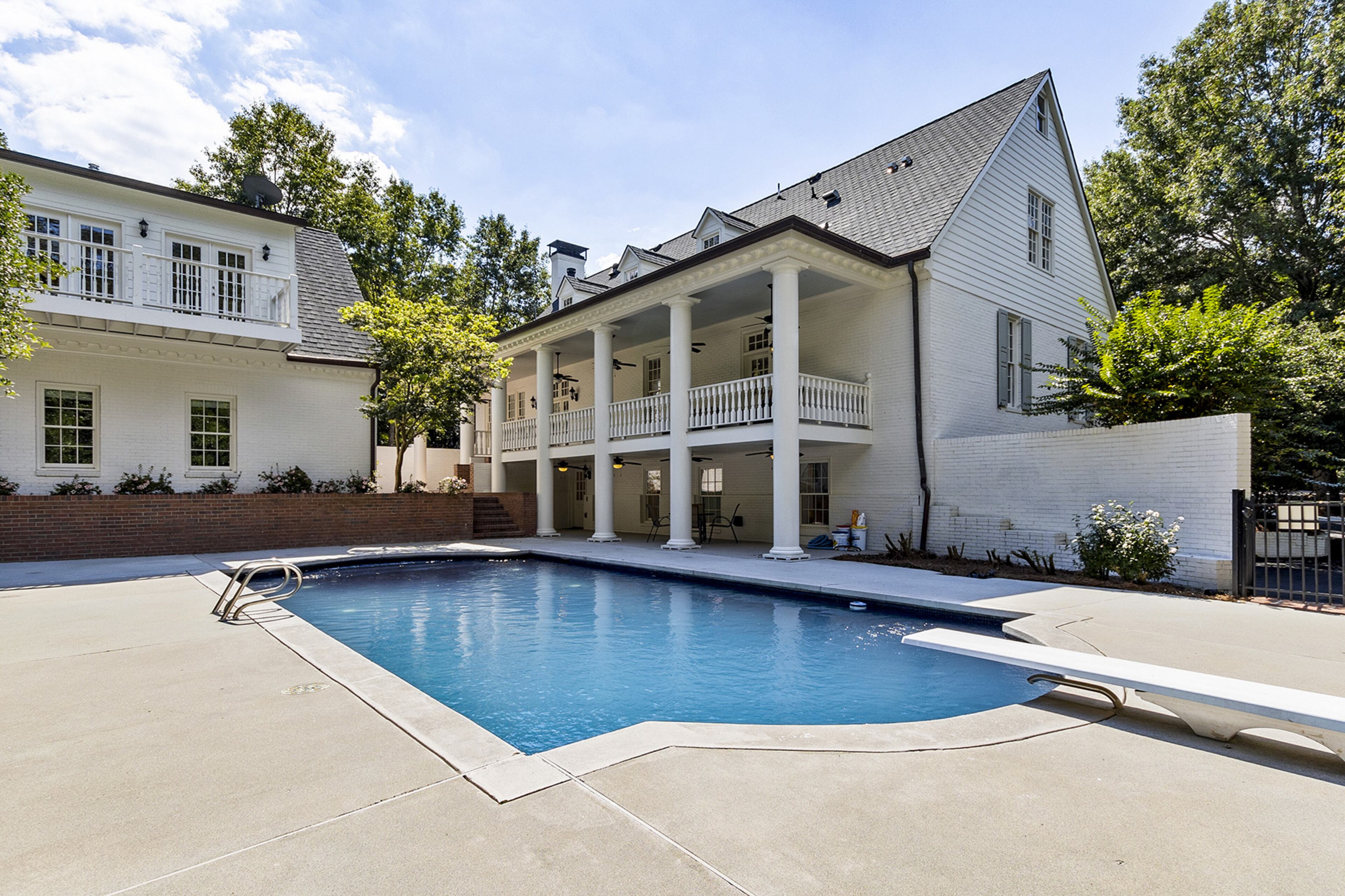 The large, private backyard features two covered porches overlooking the large Gunite pool and wooded backyard. Text by Christine Bradley Team