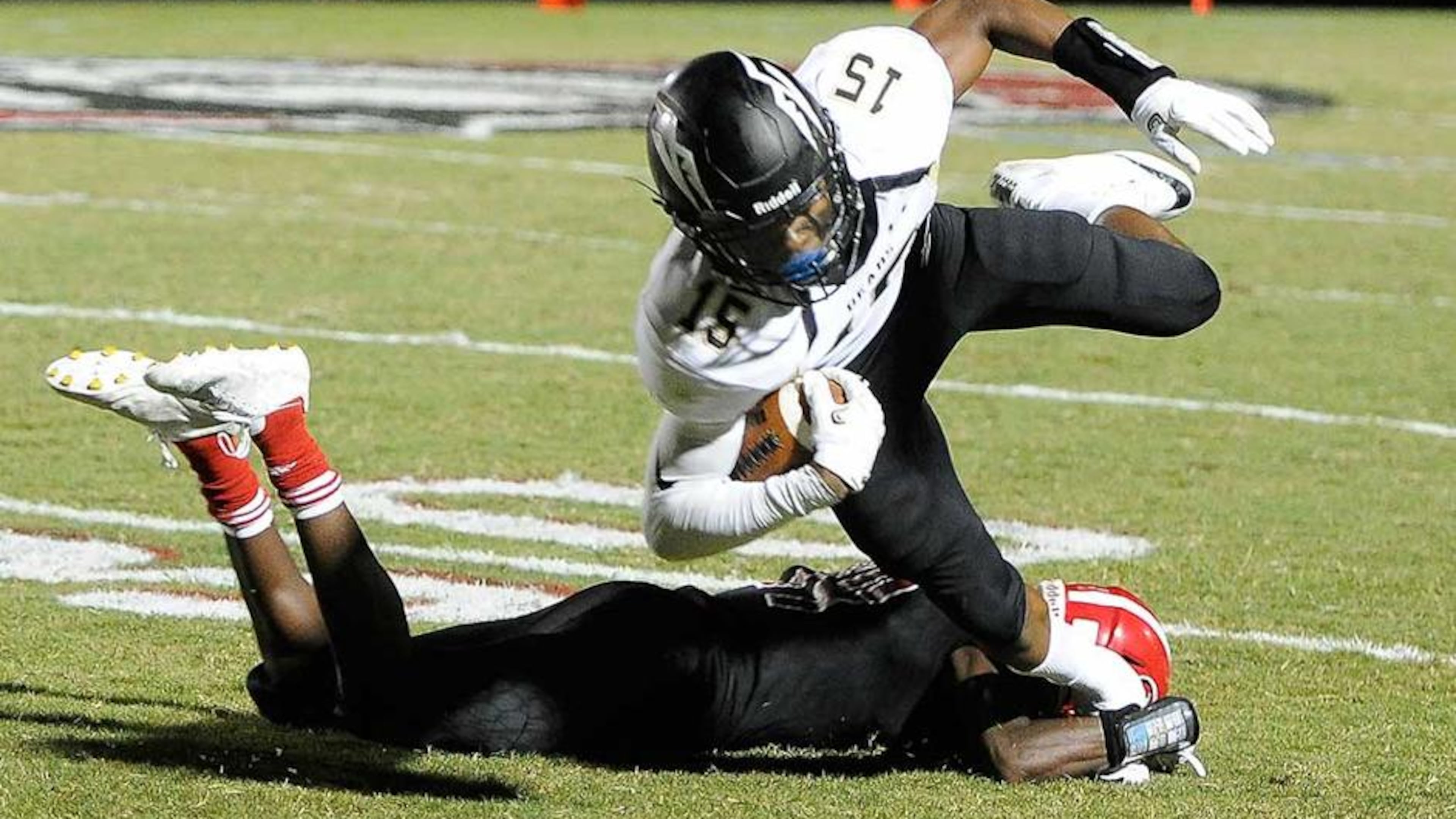 Mountain View WR Malachi Carter (15) gets tripped up by North Gwinnett DE Dixon Yellott during the first half of Friday's game. (John Amis/Special)