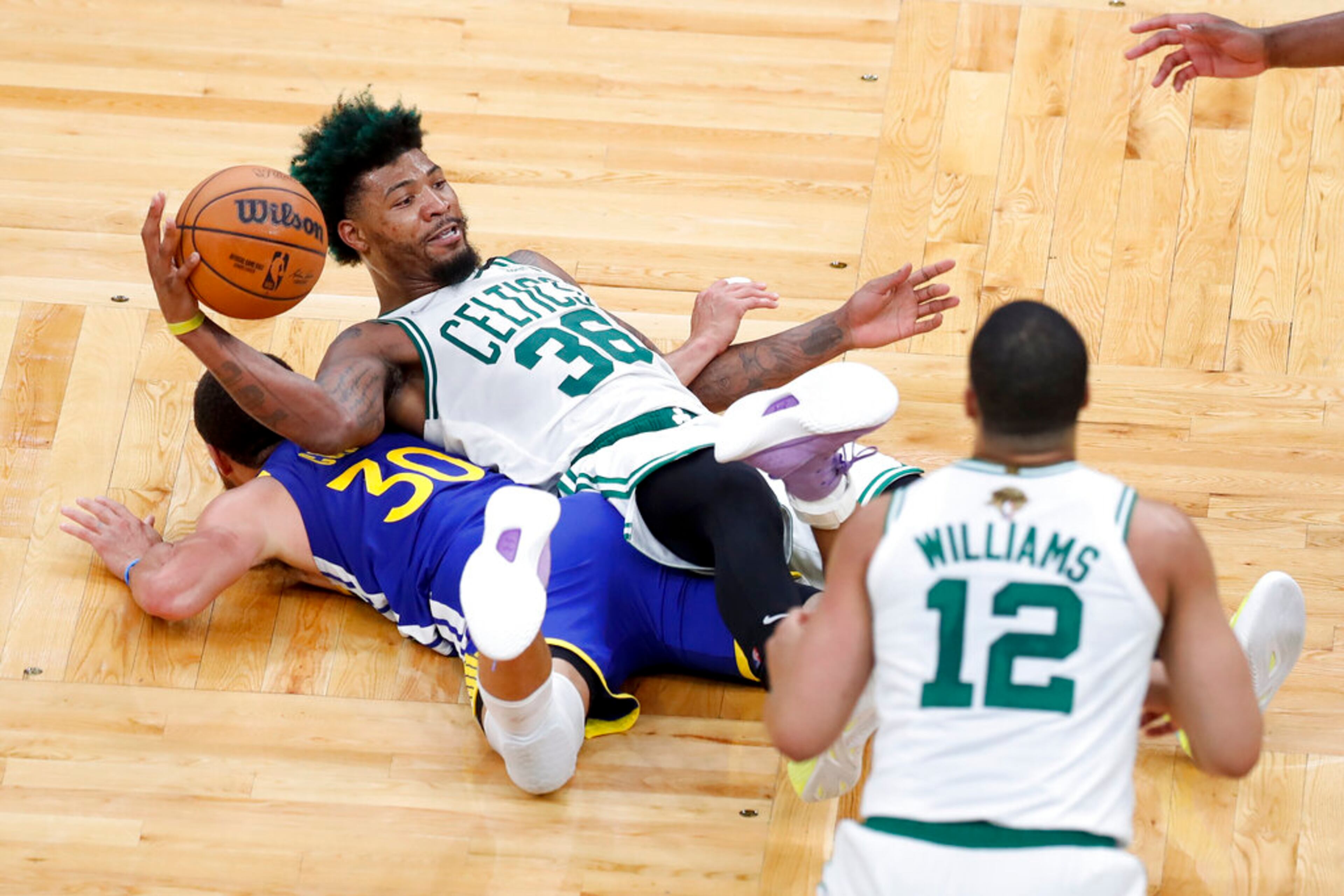 Boston Celtics forward Sam Hauser (30) scrambles for a loose ball against Golden State Warriors guard Stephen Curry (30) during the fourth quarter of Game 6 of basketball's NBA Finals, Thursday, June 16, 2022, in Boston. (AP Photo/Michael Dwyer)