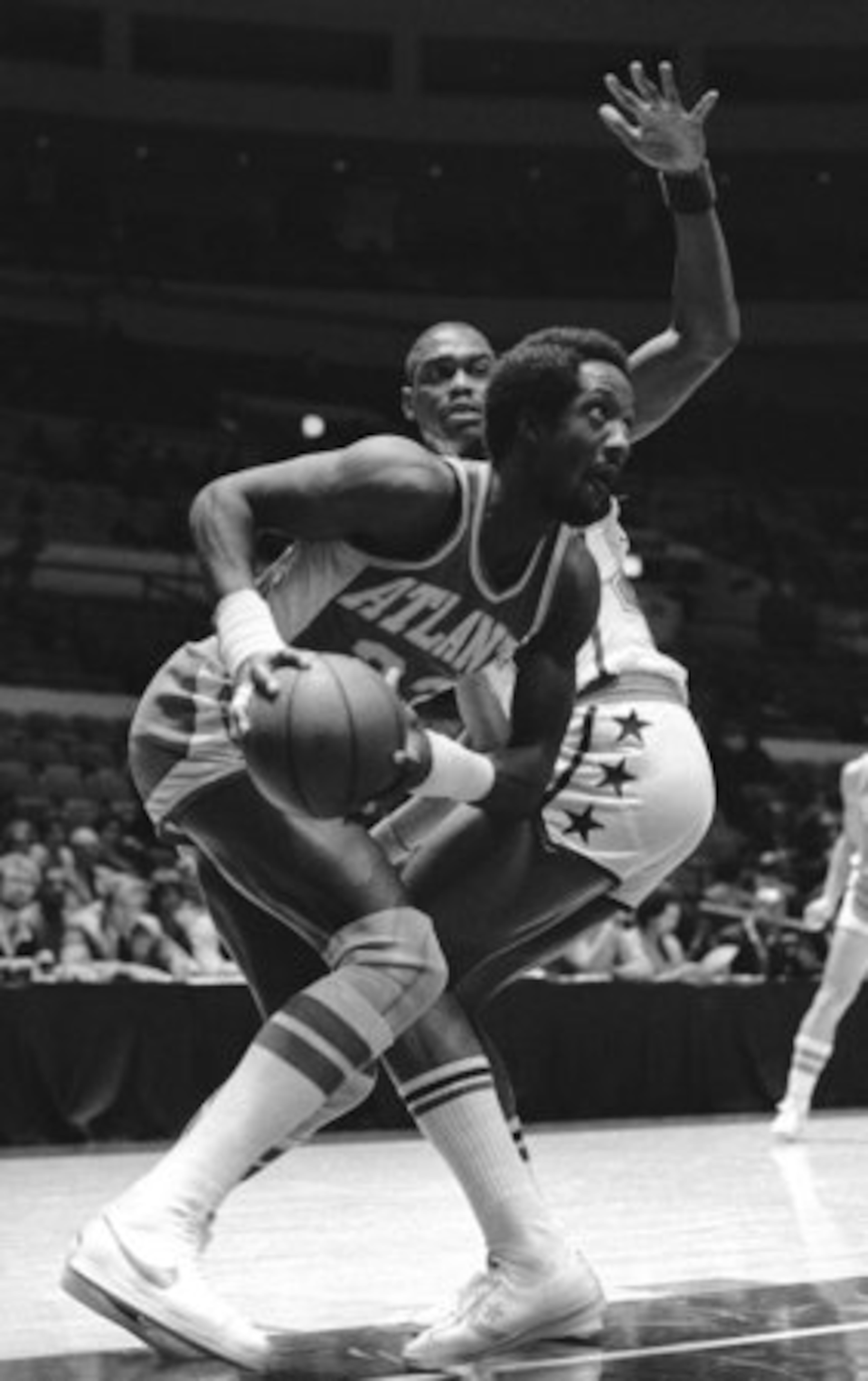 This Sept. 27, 1980 file photo shows Atlanta Hawks forward Dan Roundfield looking for an opening as he is defended by Washington Bullets' Rick Mahorn, during an NBA exhibition basketball game at New York's Madison Square Garden.