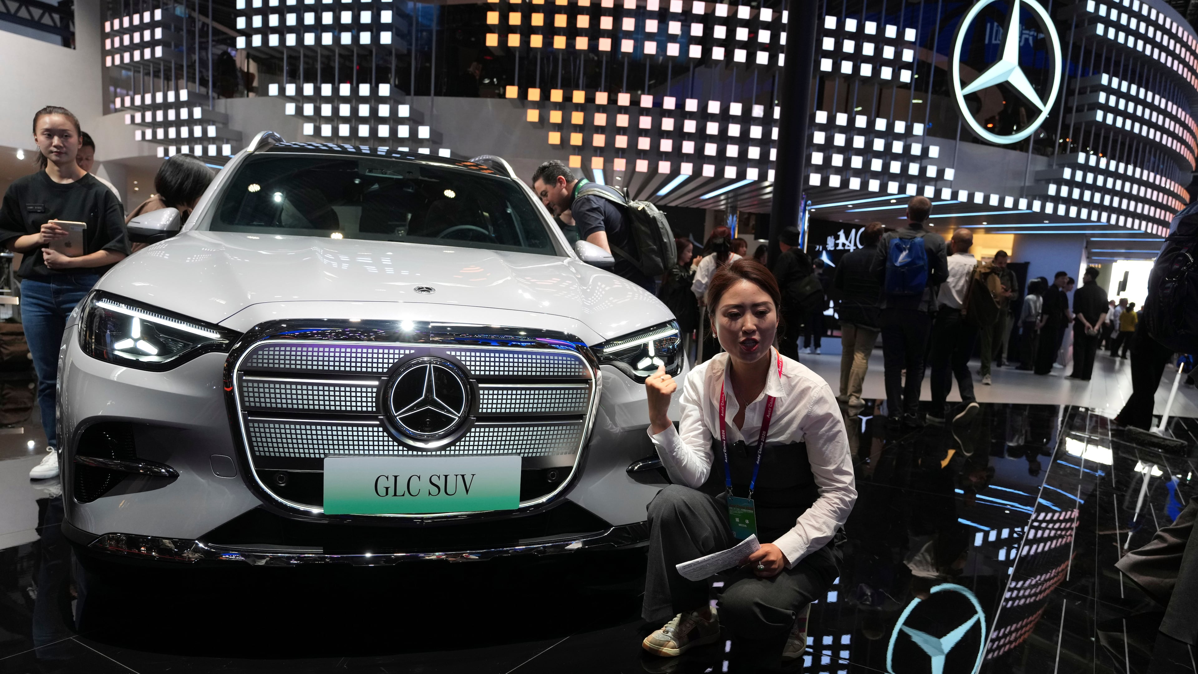 FILE - A vlogger promotes the GLC SUV at the Mercedes-Benz booth during Auto China 2026 in Beijing, on April 24, 2026. Major German carmakers saw sharp quarterly sales declines in China, as domestic demand weakened and competition heats up in the world’s biggest auto market. (AP Photo/Ng Han Guan)