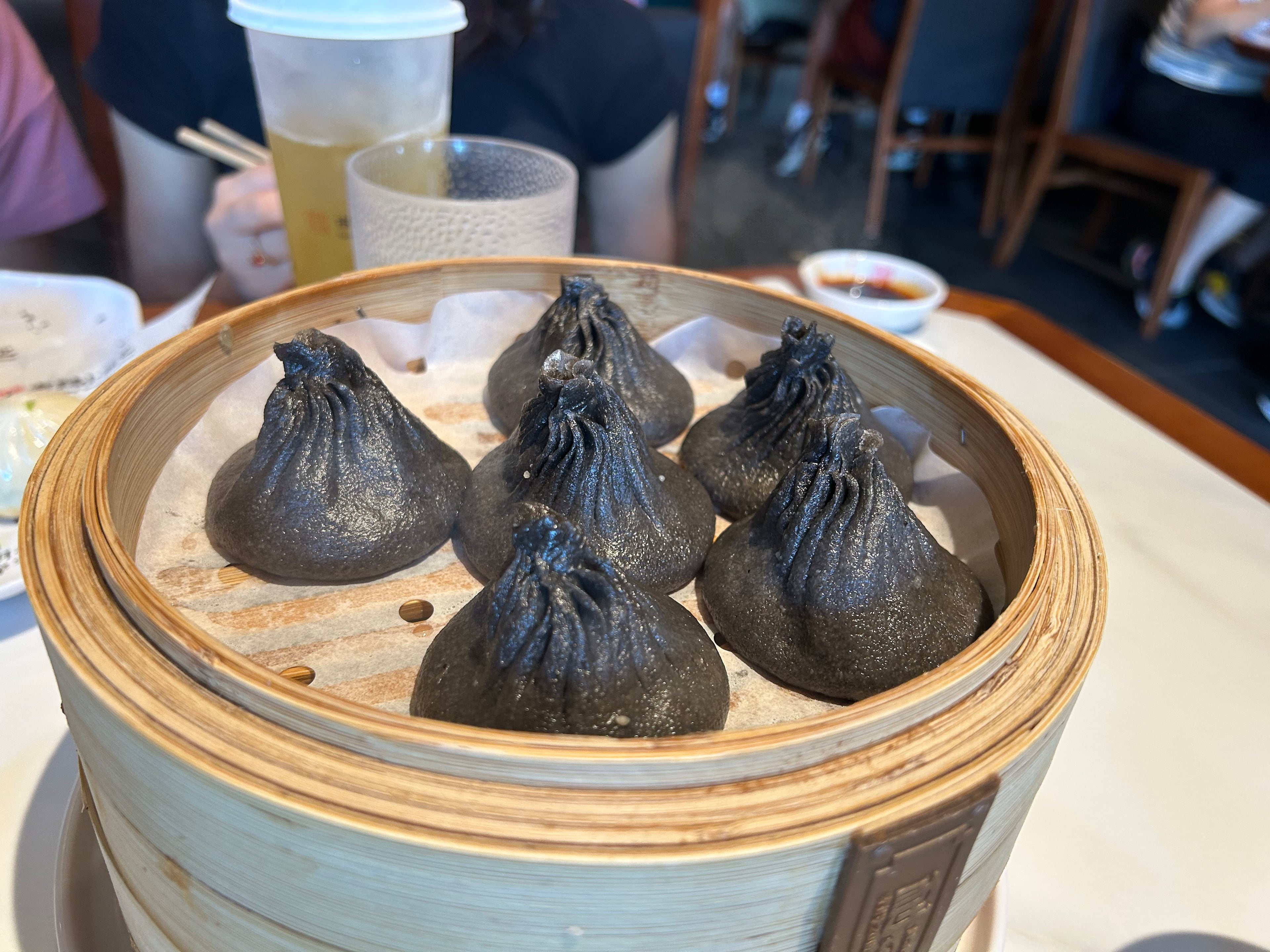 Black truffle and pork soup dumplings in a bamboo steamer. (Candy Hom for the AJC)
