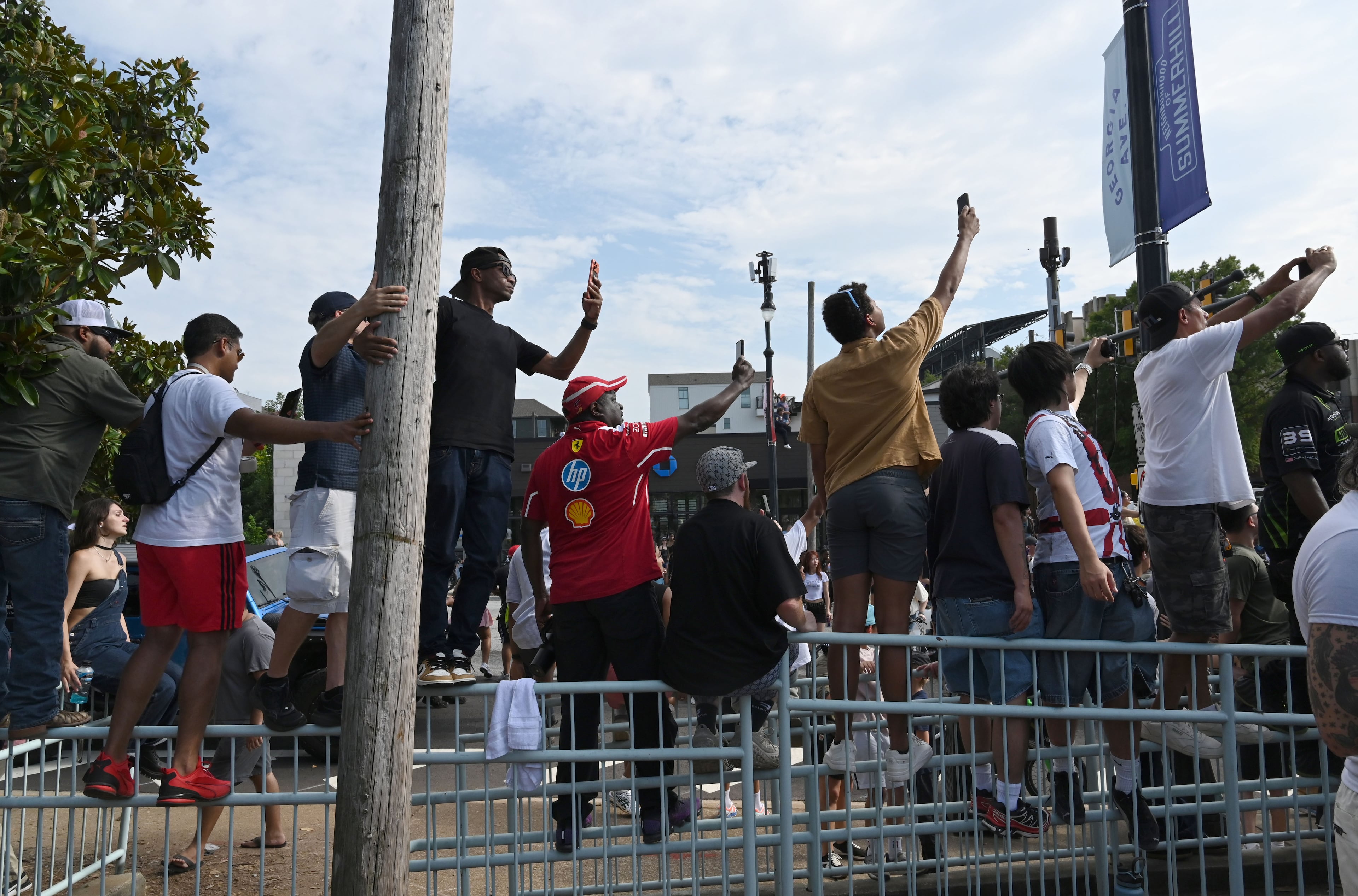 Spectators hold up their smartphones to capture a demonstration run on Hank Aaron Drive during the Red Bull Showrun Atlanta Presented by Ford Racing on Saturday, Aug. 1, 2026, in Atlanta. Atlanta city officials this week approved permits for the Red Bull Showrun that will allow the live motorsports demonstration event to go on as advertised along a roughly half-mile stretch of Hank Aaron Drive — a backup location after earlier plans to hold the event near Piedmont Park ran into opposition from Midtown residents. (Hyosub Shin/AJC)