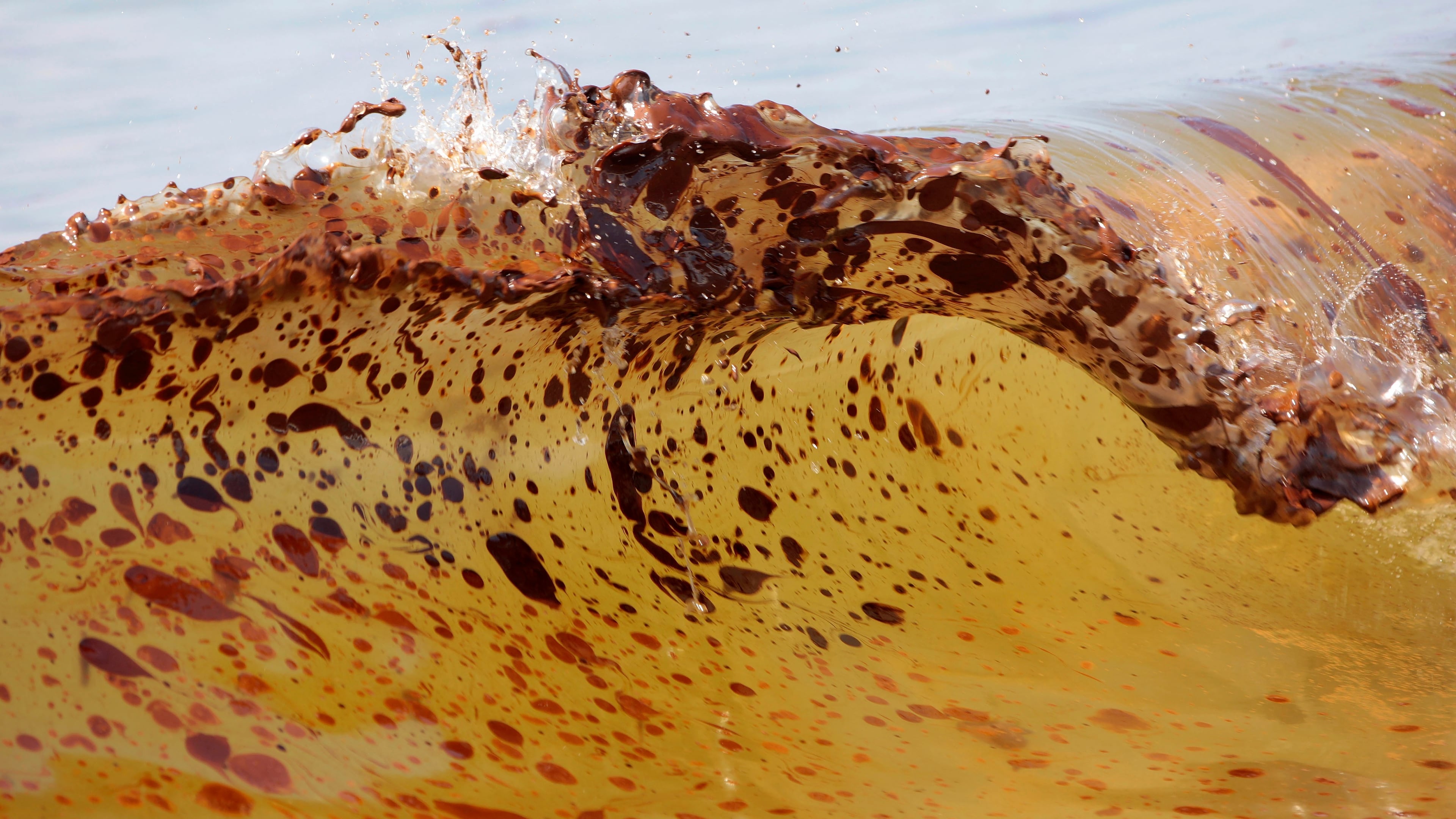 FILE - Crude oil from the Deepwater Horizon oil spill washes ashore in Orange Beach, Ala., June 12, 2010. (AP Photo/Dave Martin, File)