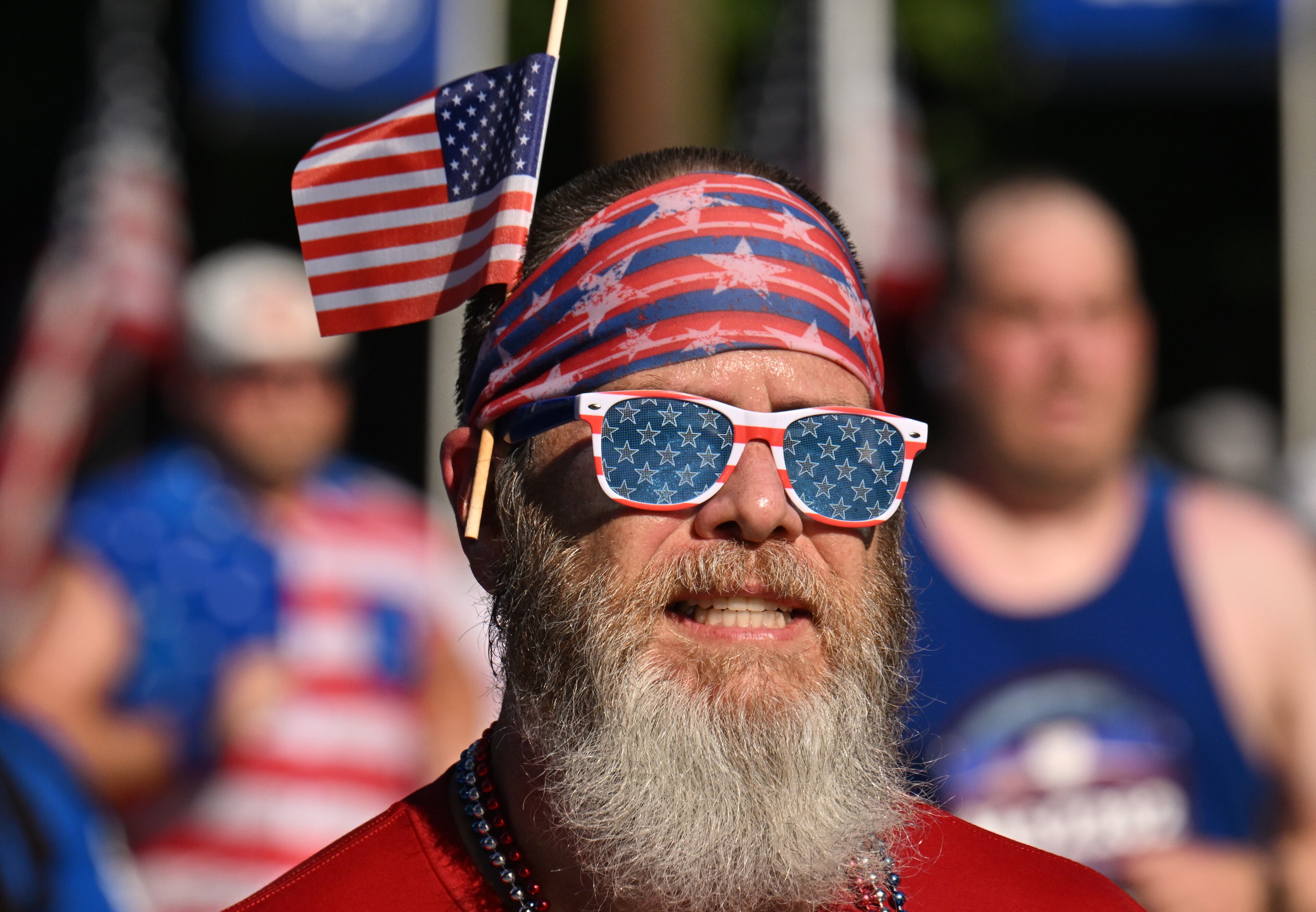 Runners celebrate as they cross the finish line of the 56th running of the Atlanta Journal-Constitution Peachtree Road Race in Atlanta on Friday, July 4, 2025. (Hyosub Shin / AJC)