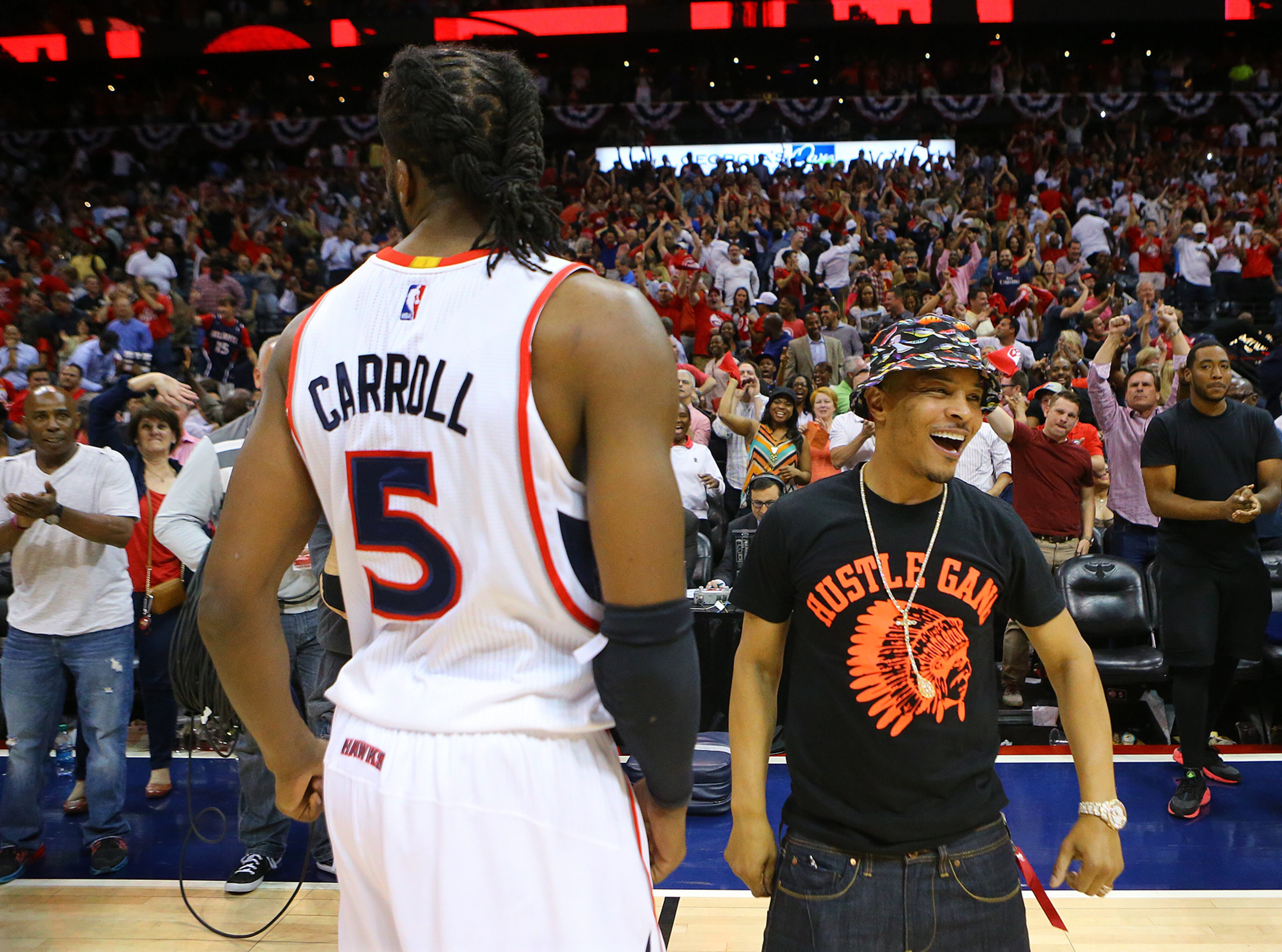 Rapper, producer and actor T.I. comes out on the court to celebrate with Hawks DeMarre Carroll after defeating the Wizards 82-81 in their Eastern Conference Semifinals game 5 on Tuesday, May 13, 2015, in Atlanta. Curtis Compton / ccompton@ajc.com