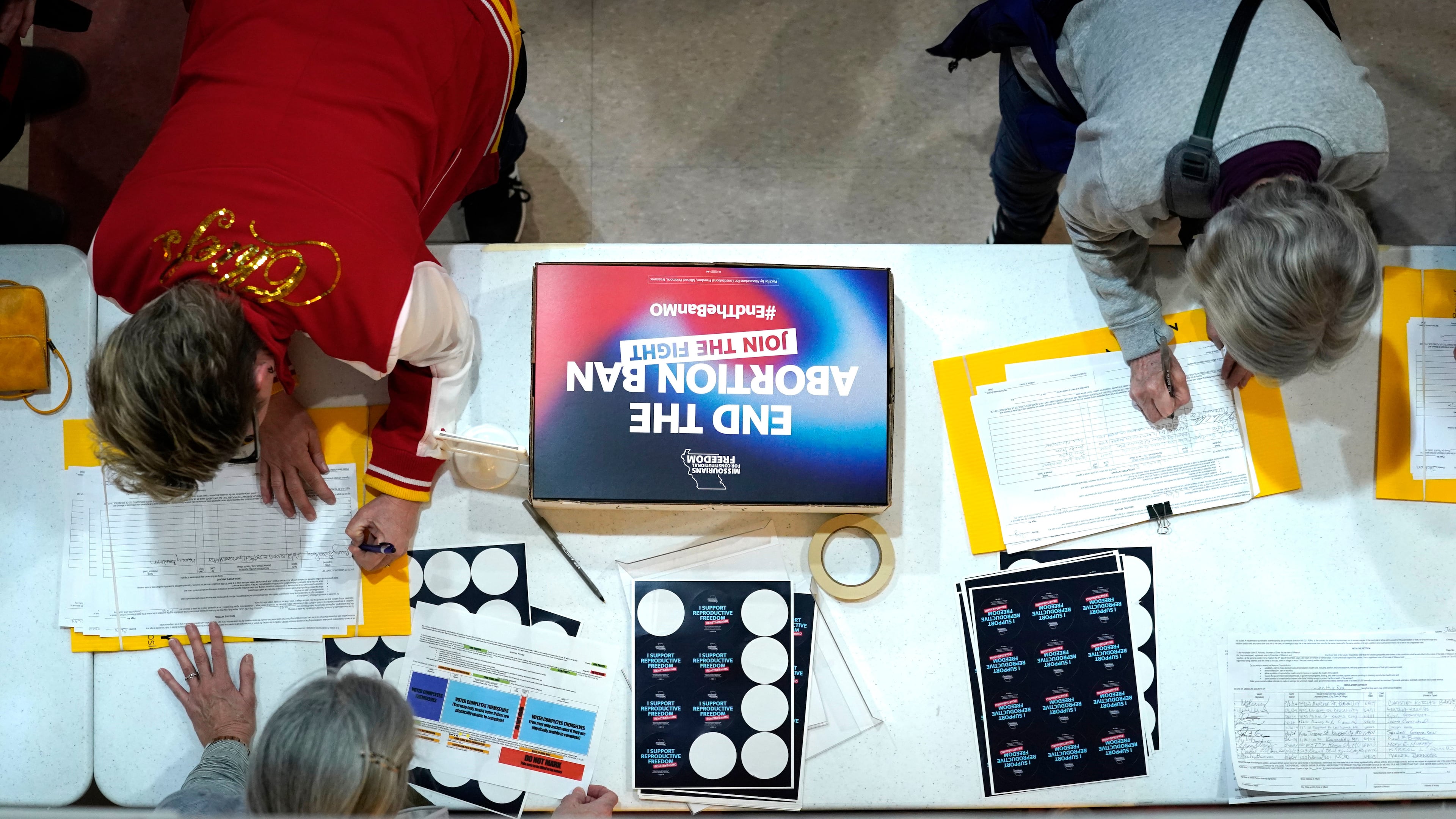 FILE - Residents place their signatures on a petition in support of a ballot initiative to end Missouri's near-total ban on abortion during Missourians for Constitutionals Freedom kick-off petition drive, Feb. 6, 2024, in Kansas City, Mo. (AP Photo/Ed Zurga, File)