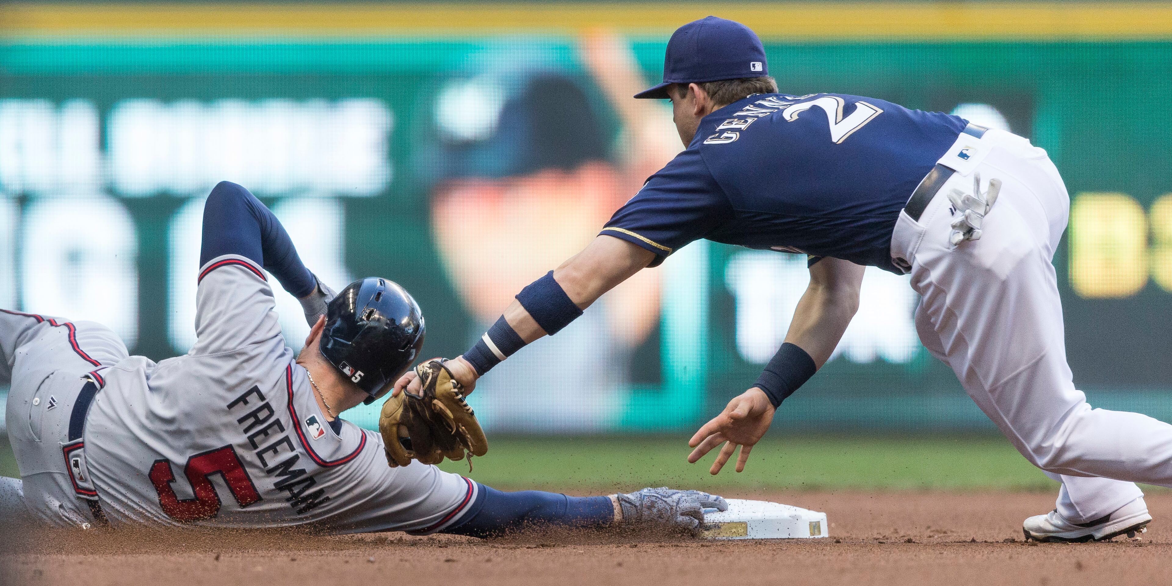 Milwaukee Brewers' Scooter Gennett is late with the tag on Atlanta Braves' Freddie Freeman who is in with a double during the fourth inning of a baseball game, Monday, Aug. 8, 2016, in Milwaukee. (AP Photo/Tom Lynn)