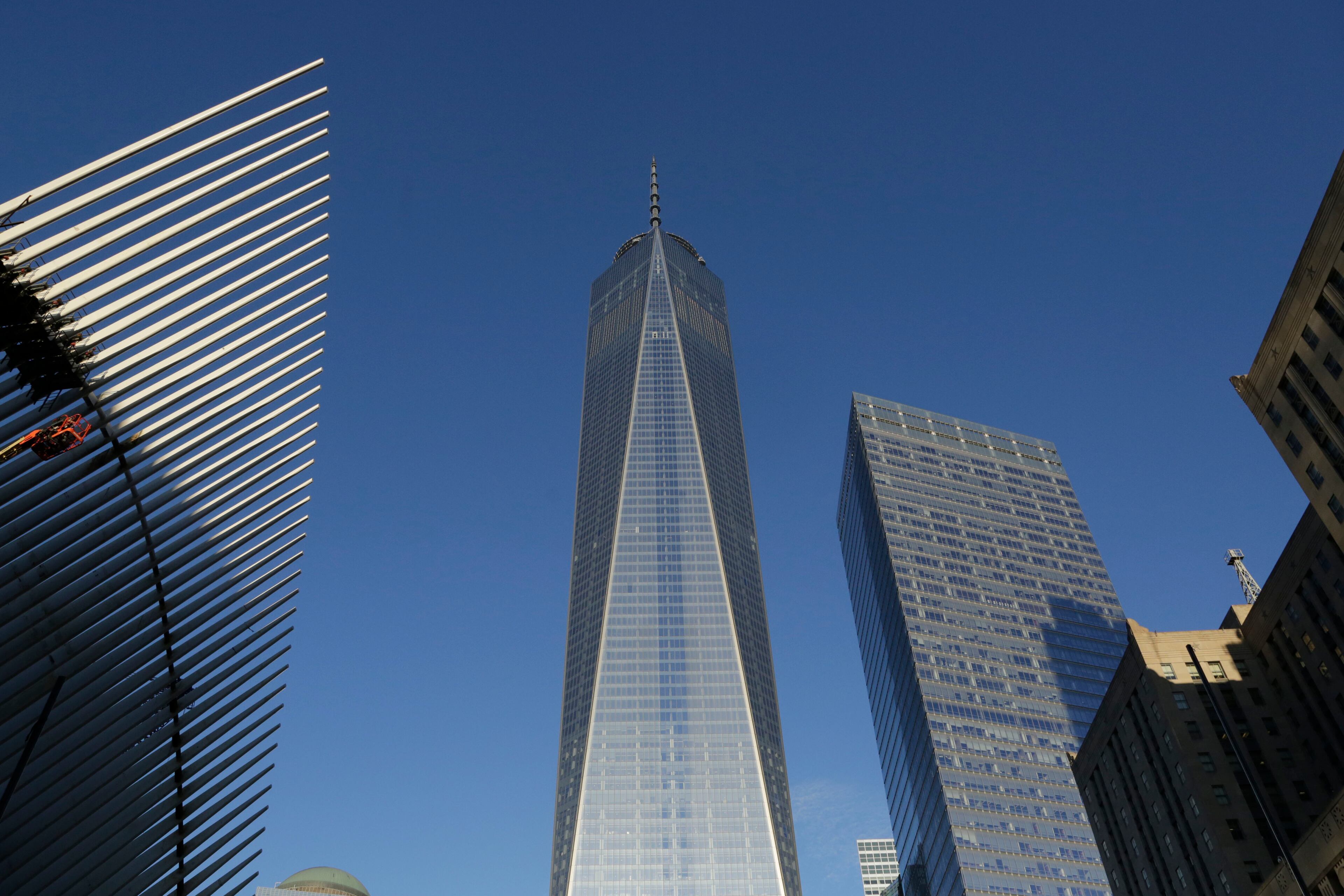 One World Trade Center, center, stands between the transportation hub, left, still under construction, and 7 World Trade Center, second from right, Monday, Nov. 3, 2014 in New York. (AP Photo/Mark Lennihan)