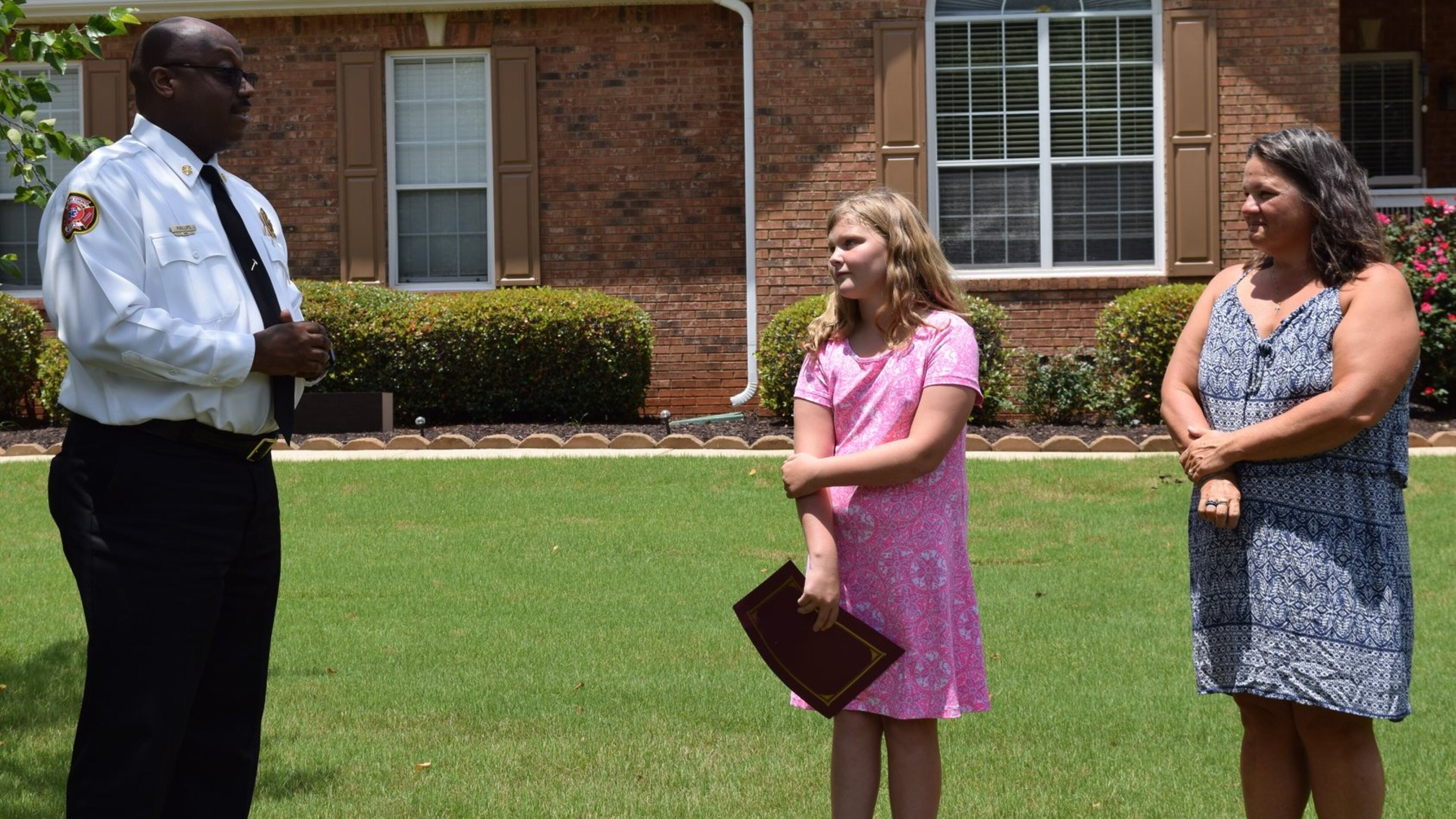 HCFD chief Luther Phillips with Marley Parker and Melissa Rommelman.