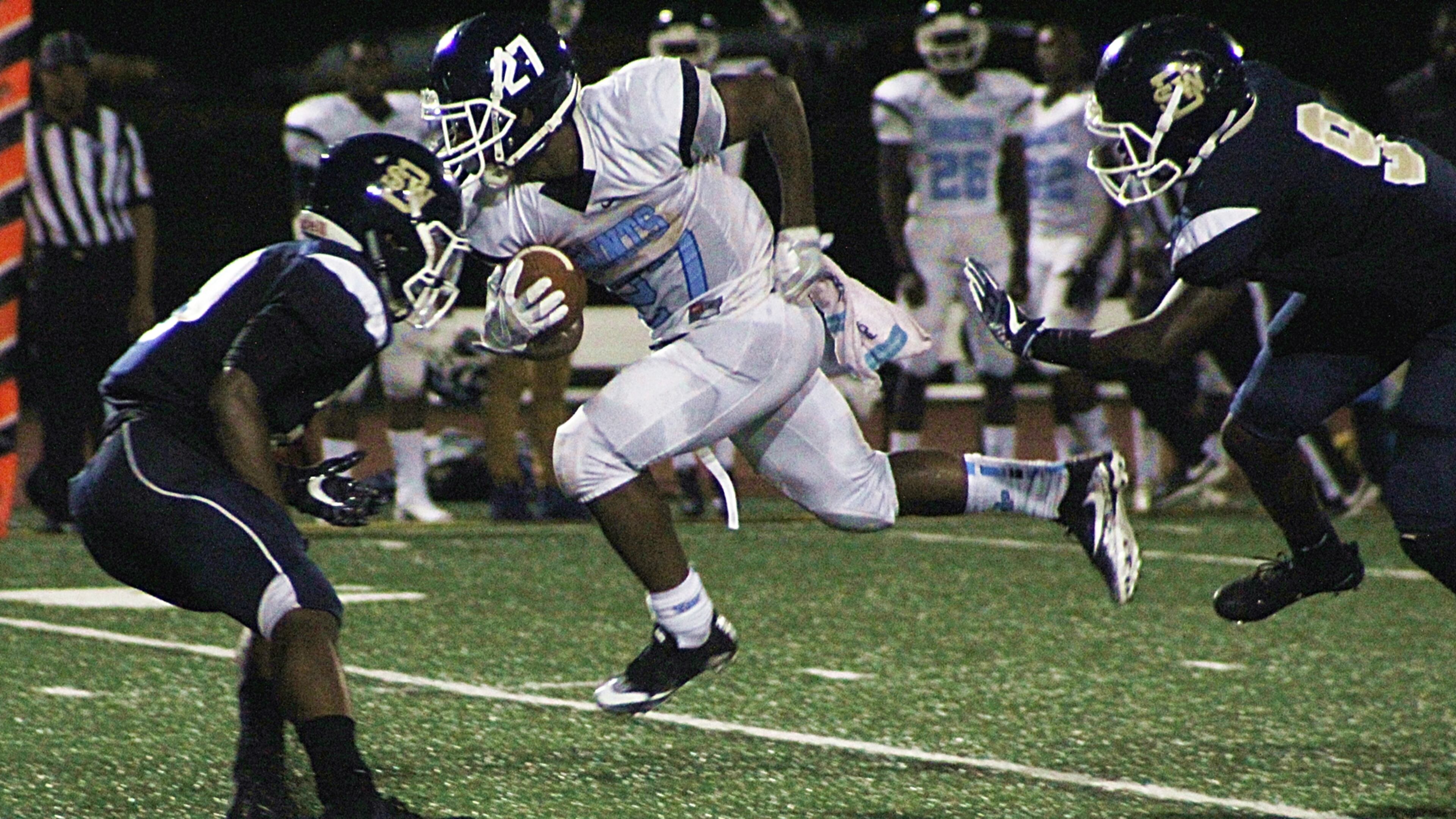 Cedar Grove's Darrel Neal churns up the middle as Southwest DeKalb's Jervon Mannery is in pursuit. (Photo - Mark Brock)