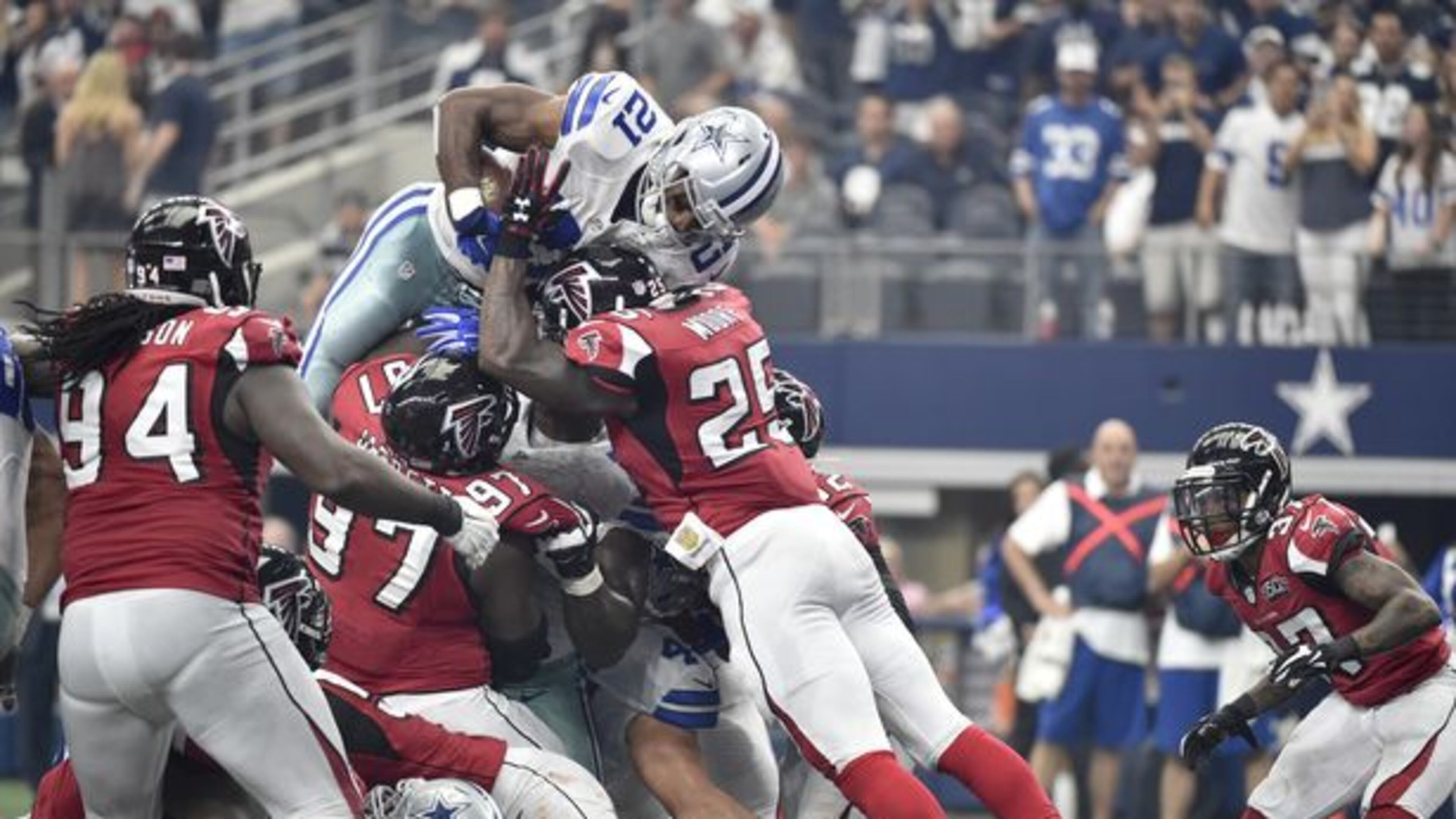Dallas Cowboys running back Joseph Randle (21) leaps over Atlanta Falcons' Tyson Jackson (94), Grady Jarrett (97) and William Moore (25) as Ricardo Allen (37) watches for a touchdown in the first half of an NFL football game, Sunday, Sept. 27, 2015, in Arlington, Texas. (AP Photo/Michael Ainsworth)