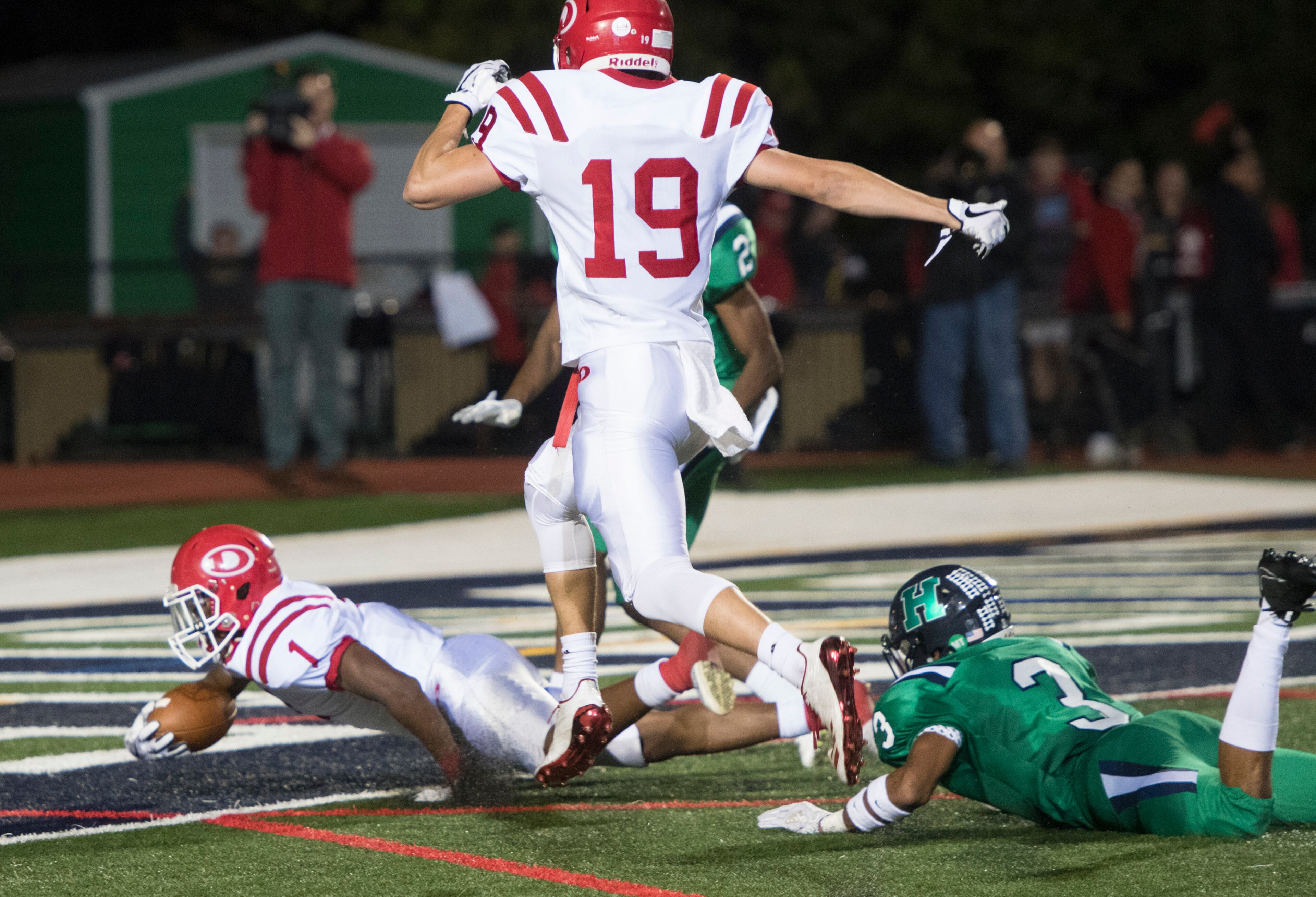 Dalton running back Jahmyr Gibbs (1) scores with Harrison cornerback Marquis Alston (3) on the ground and Chandler Starks (19) following behind during a high school football game on Thursday, Oct. 19, 2017, in Kennesaw, Ga. (Special to the Atlanta Journal-Constitution, John Amis )