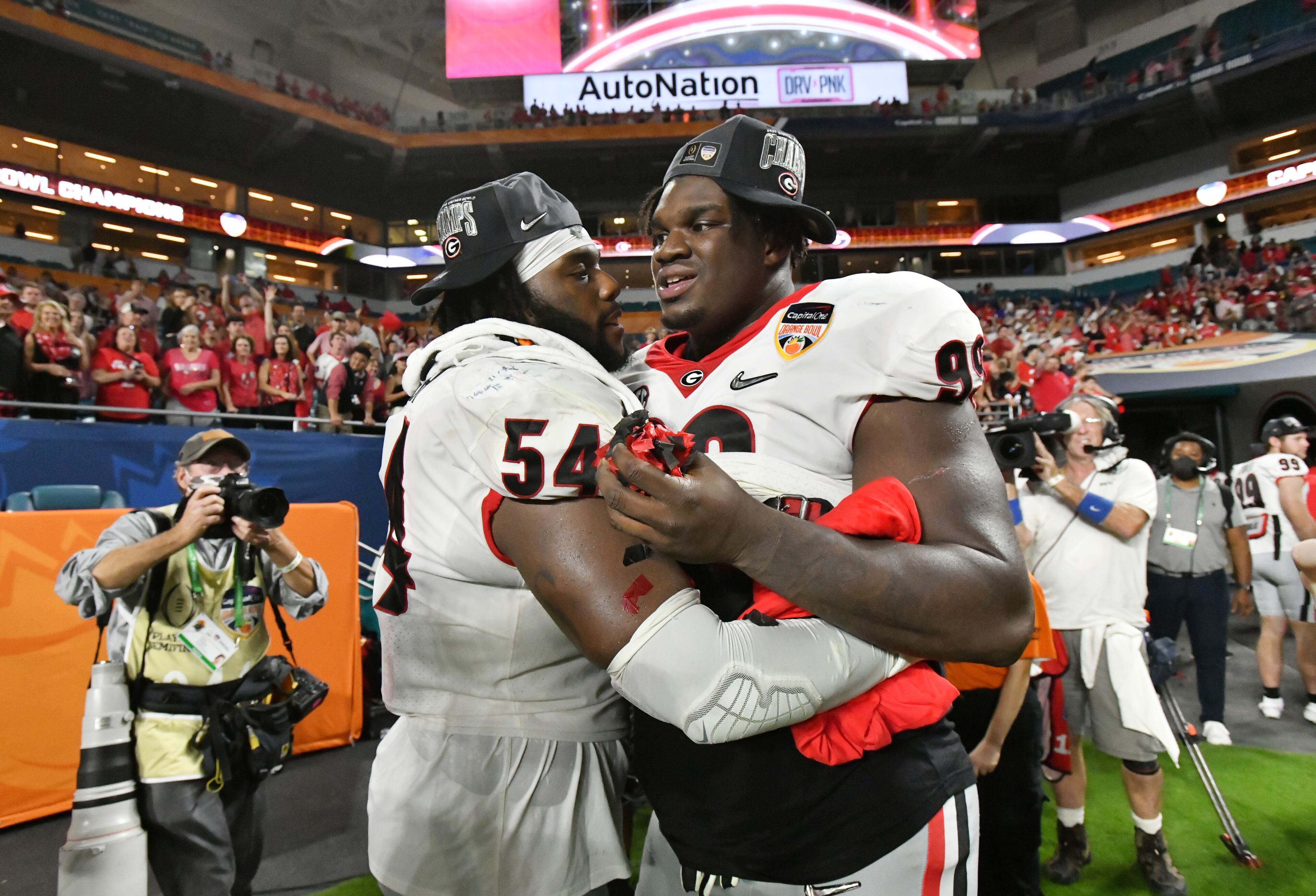 Georgia linebacker Cade Brock (54) and Georgia defensive lineman Jordan Davis (99) celebrate after they won Orange Bowl over Michigan at Hard Rock Stadium in Miami Gardens, Florida on Friday, December 31, 2021. (Hyosub Shin / Hyosub.Shin@ajc.com)