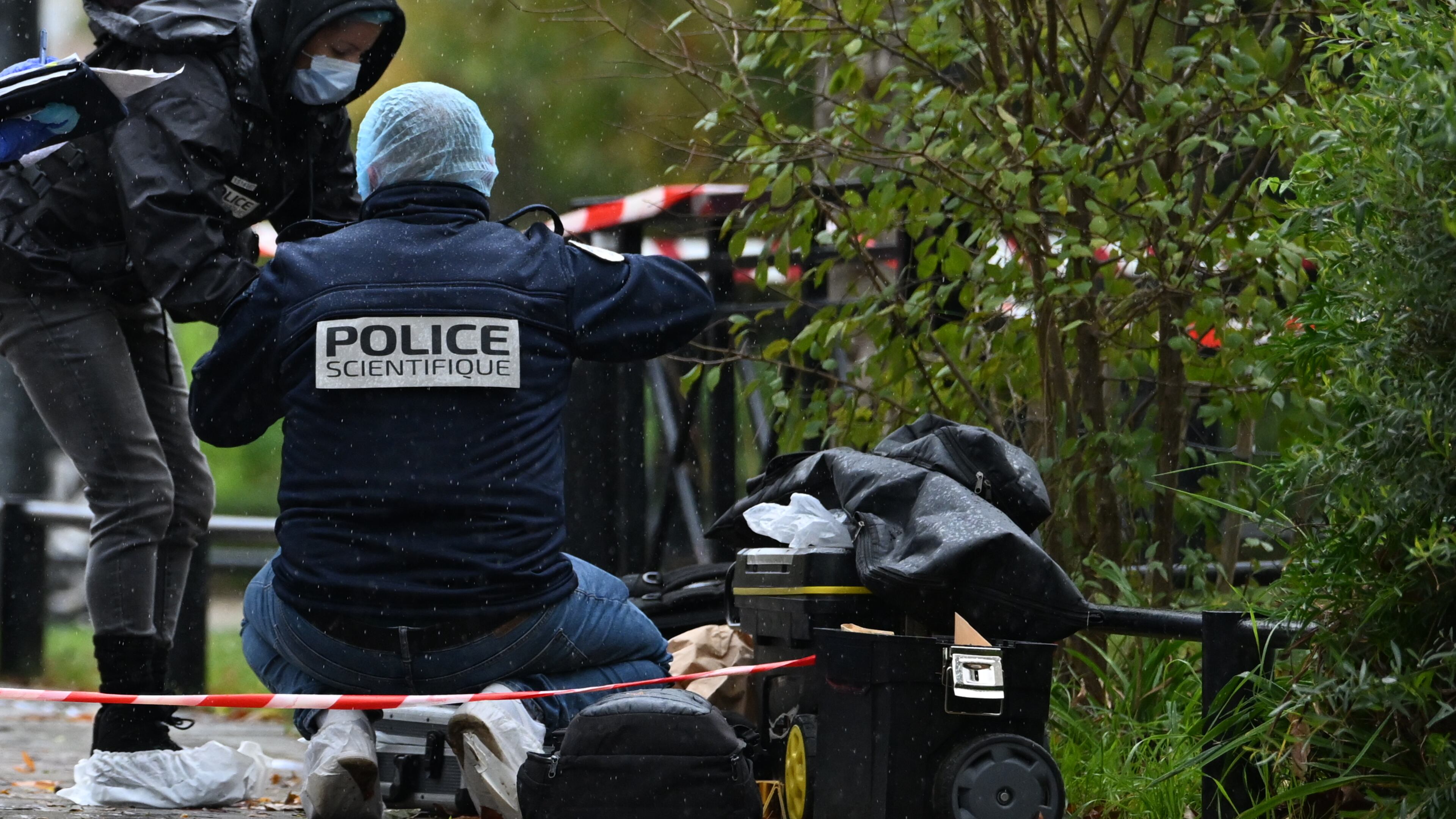 Forensic investigators search for evidence after a shooting in Trappes, outside Paris, Friday, Oct. 23, 2026. (AP Photo/Emma Da Silva)