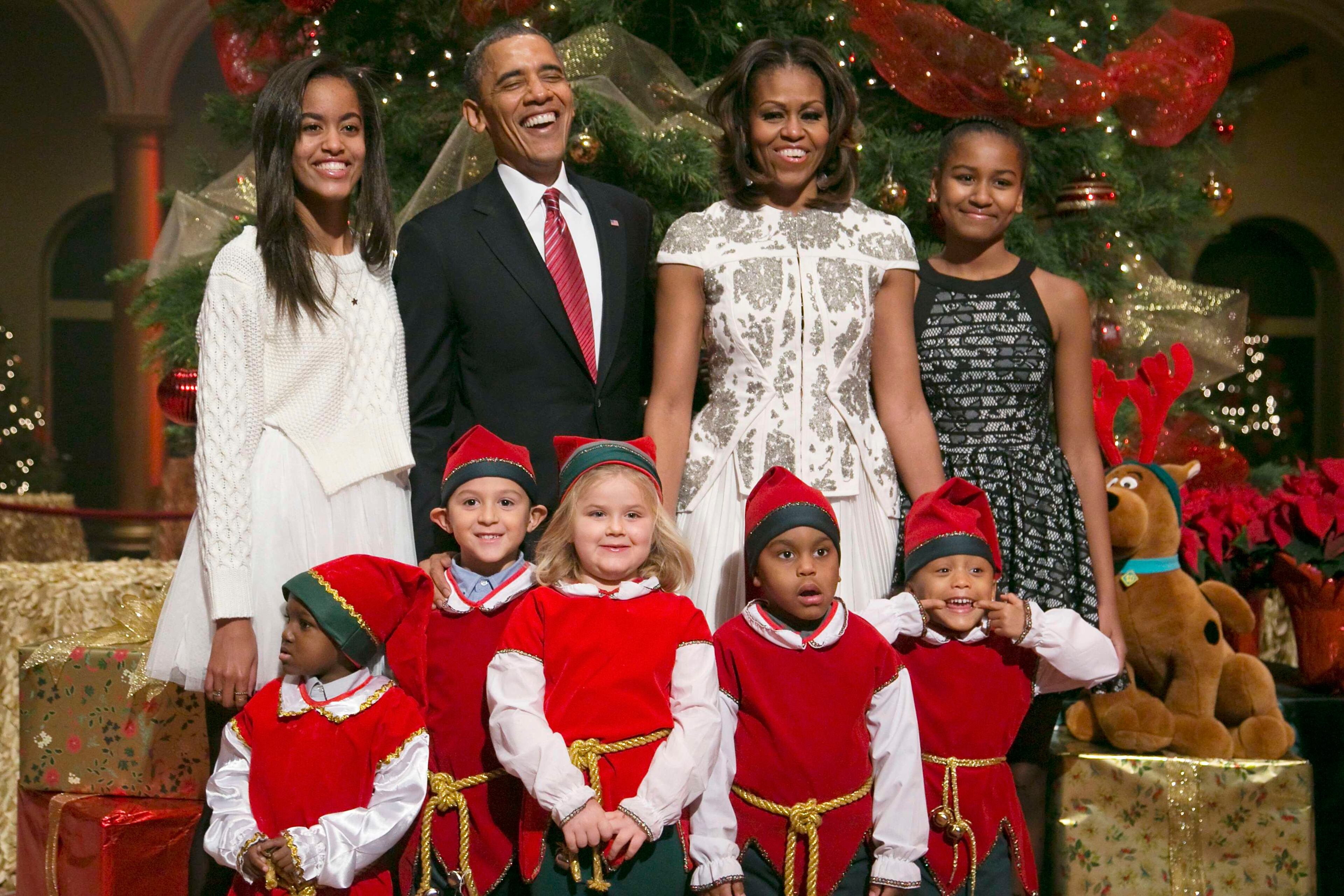U.S. President Barack Obama (2nd L), his wife Michelle (2nd R) and their daughters Malia (L) and Sasha (R) are greeted by a team of elves made up of former patients of the Children's National Medical Center, as they arrive for the "Christmas in Washington" television benefit program at the National Building Museum in Washington December 15, 2013. The 32nd annual Christmas in Washington show, benefitting the Children's National Health System, featured performers Hugh Jackman, Backstreet Boys, Sheryl Crow, Anna Kendrick, Janelle Monae and Pat Monahan.