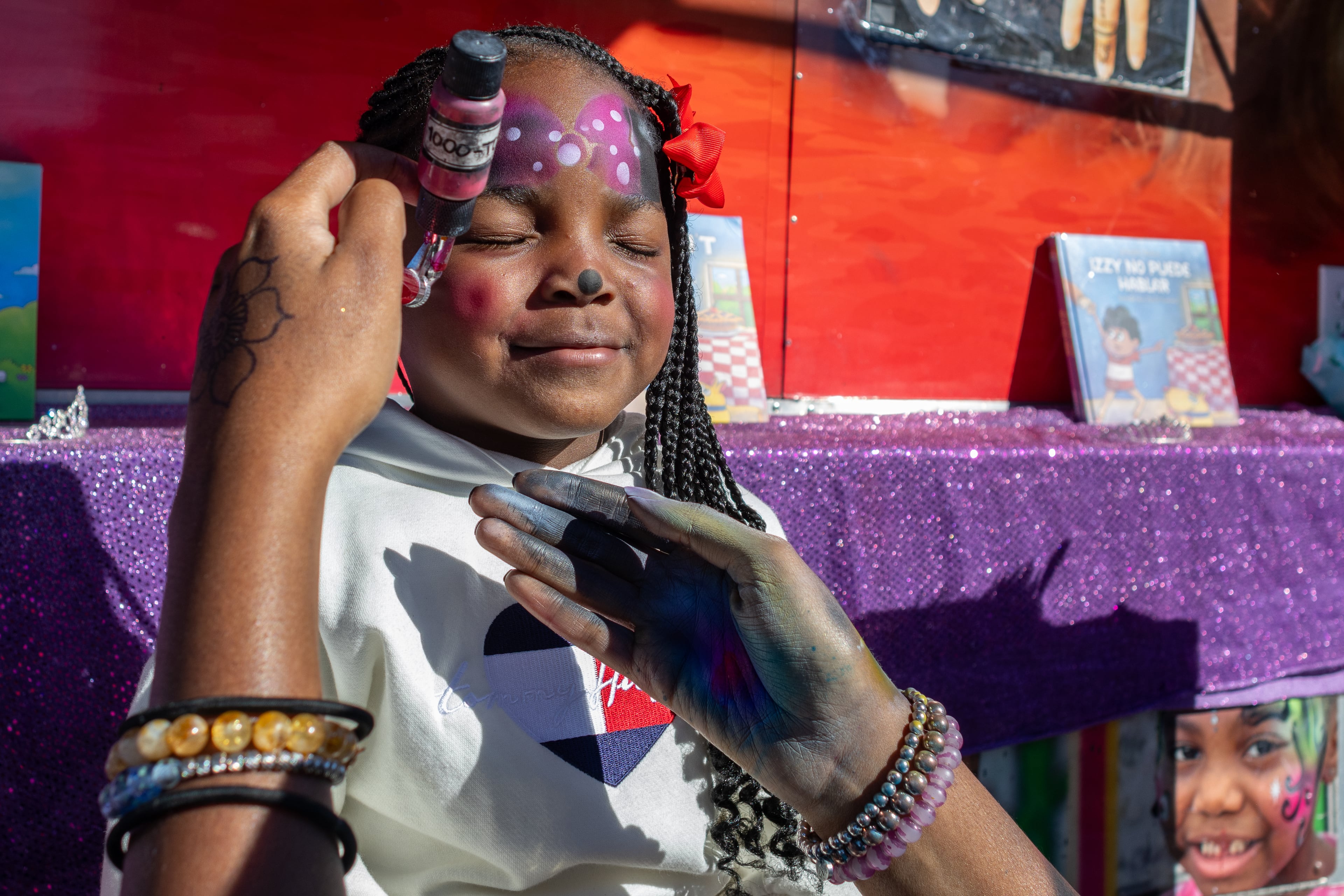 Da'Lonee Watson closes her eyes and smiles while she gets her face painted as Disney's Minnie Mouse at the 37th annual Georgia National Fair on Saturday, October 17, 2026. From Athens, Georgia, this was Watson's third time at the fair. (Wesley Webb/UGA Photojournalism Workshop)