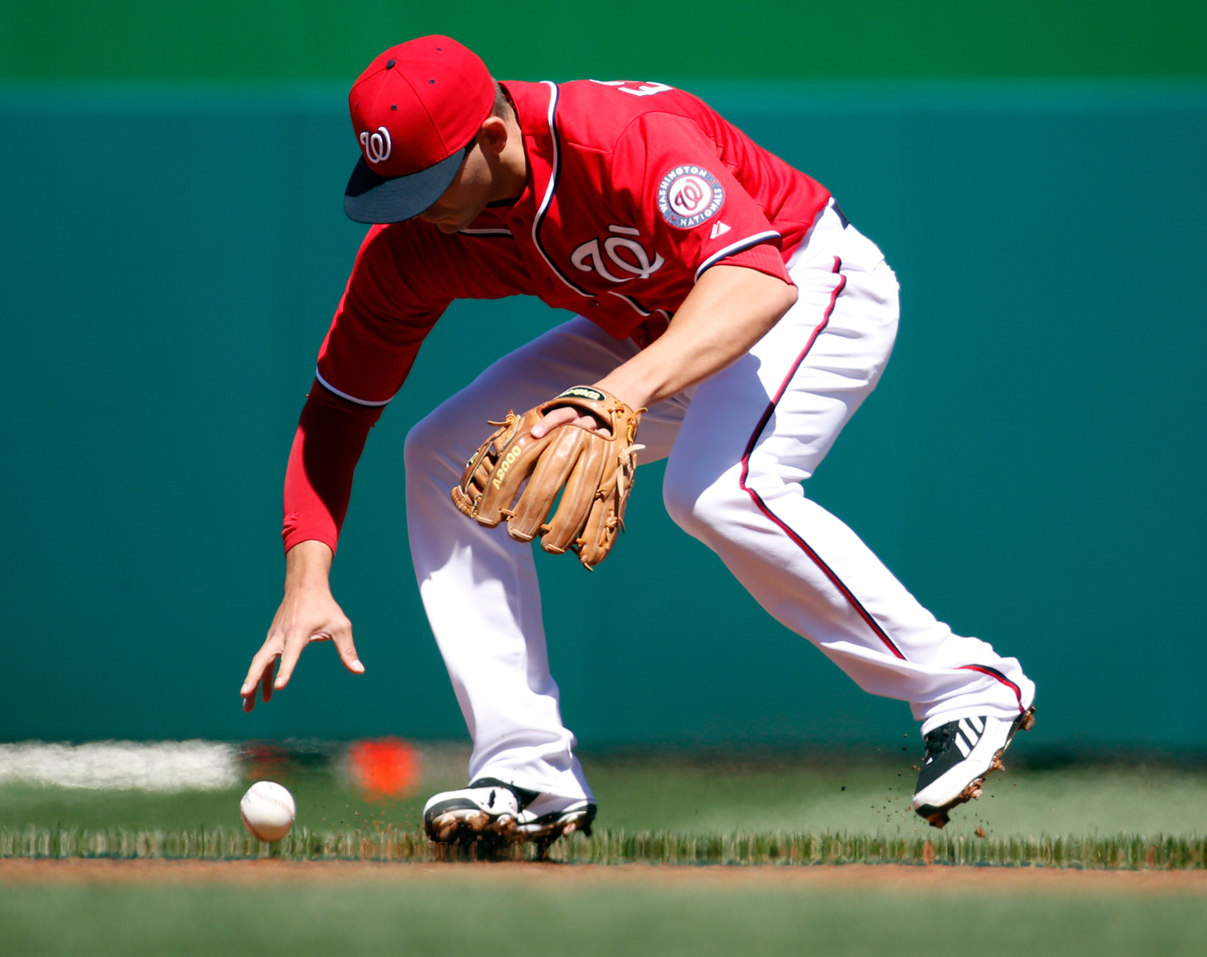 Washington Nationals second baseman Danny Espinosa cannot handle a hit by Atlanta Braves' Jason Heyward during the first inning of a baseball game at Nationals Park, Sunday, April 6, 2014, in Washington. Espinosa was charged with an error on the play. (AP Photo/Alex Brandon)