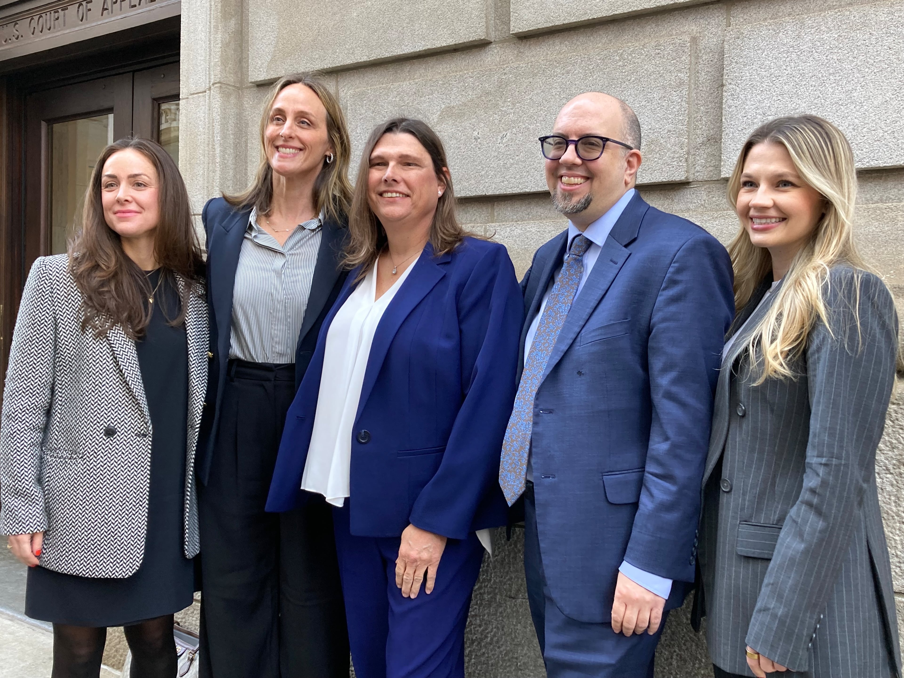 Houston County sheriff's deputy Anna Lange (center) and her lawyers pose for a photograph outside the 11th Circuit Court of Appeals in Atlanta on Tuesday, Feb. 4, 2025. (Rosie Manins / AJC)