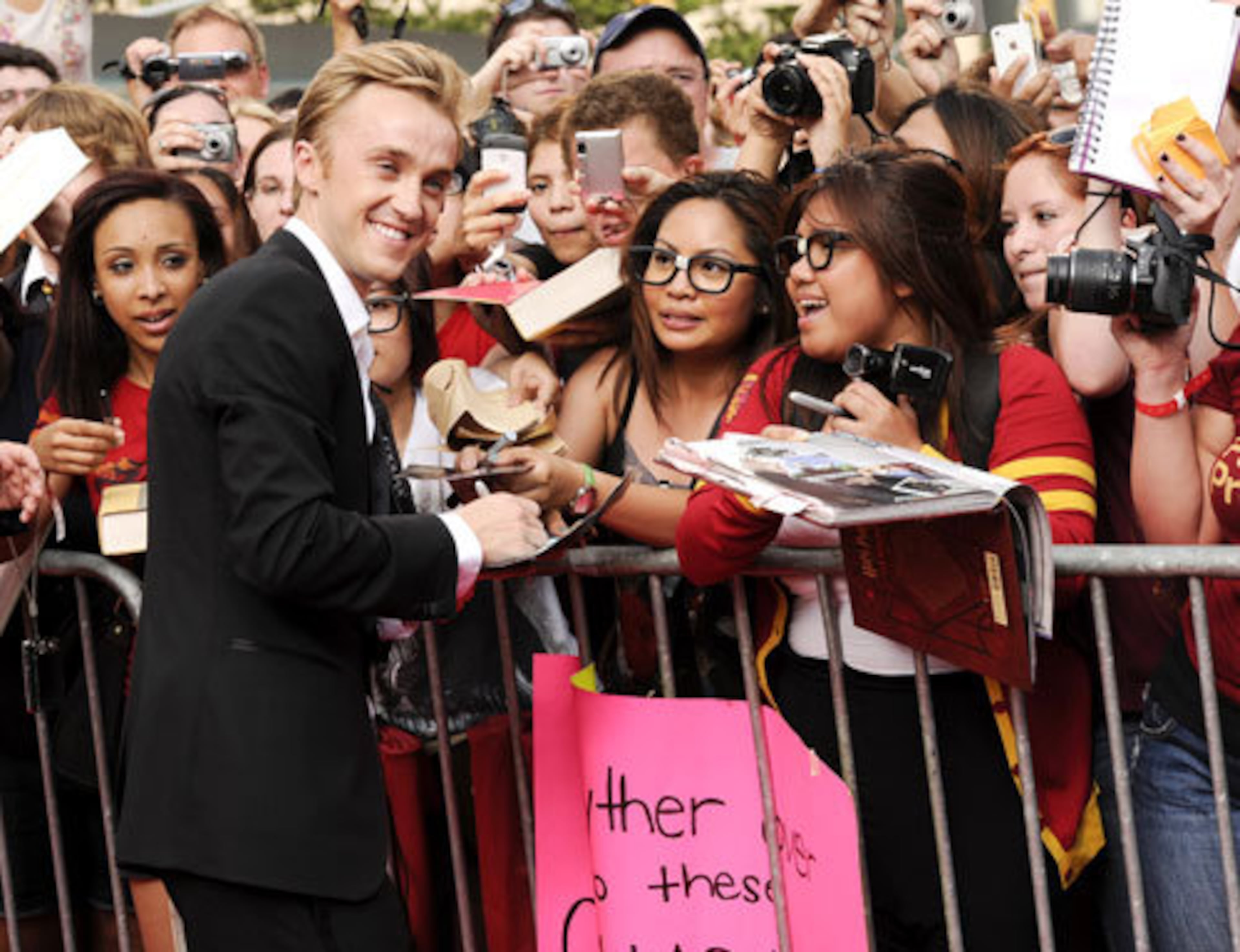 Actor Tom Felton, who plays Draco Malfoy in the films, signs autographs for fans.