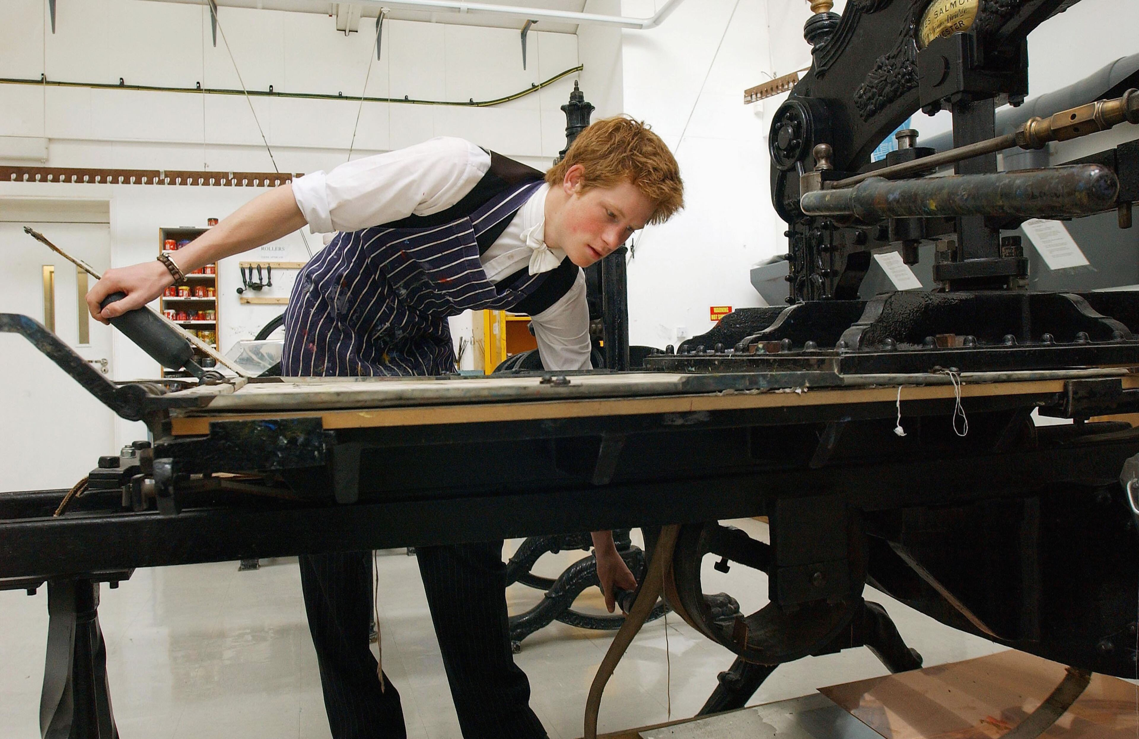 The youngest son of the Prince of Wales, Prince Harry, operates a 120-year-old Colombian relief printing press on May 12, 2003, in the Drawing School at Eton College, Eton, in England.