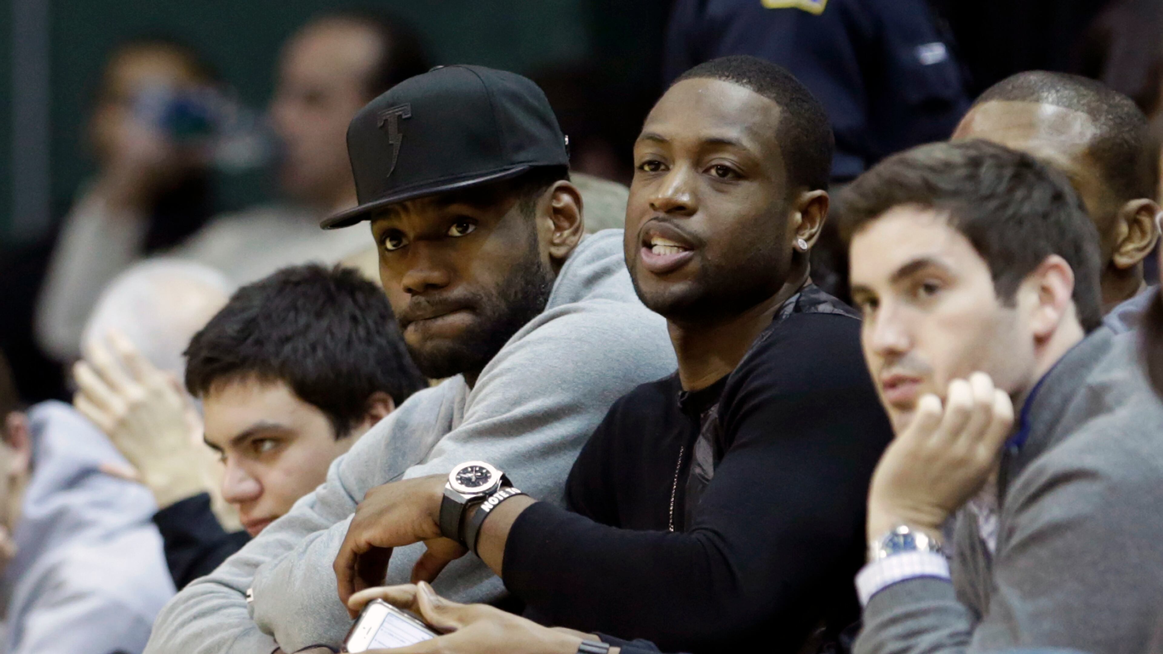 Miami Heat's LeBron James, left, and Dwyane Wade watch the NCAA basketball game between Duke and Miami during the second half of an NCAA basketball game in Coral Gables, Fla., Wednesday, Jan. 22, 2014. duke won 67-46. (AP Photo/Alan Diaz)