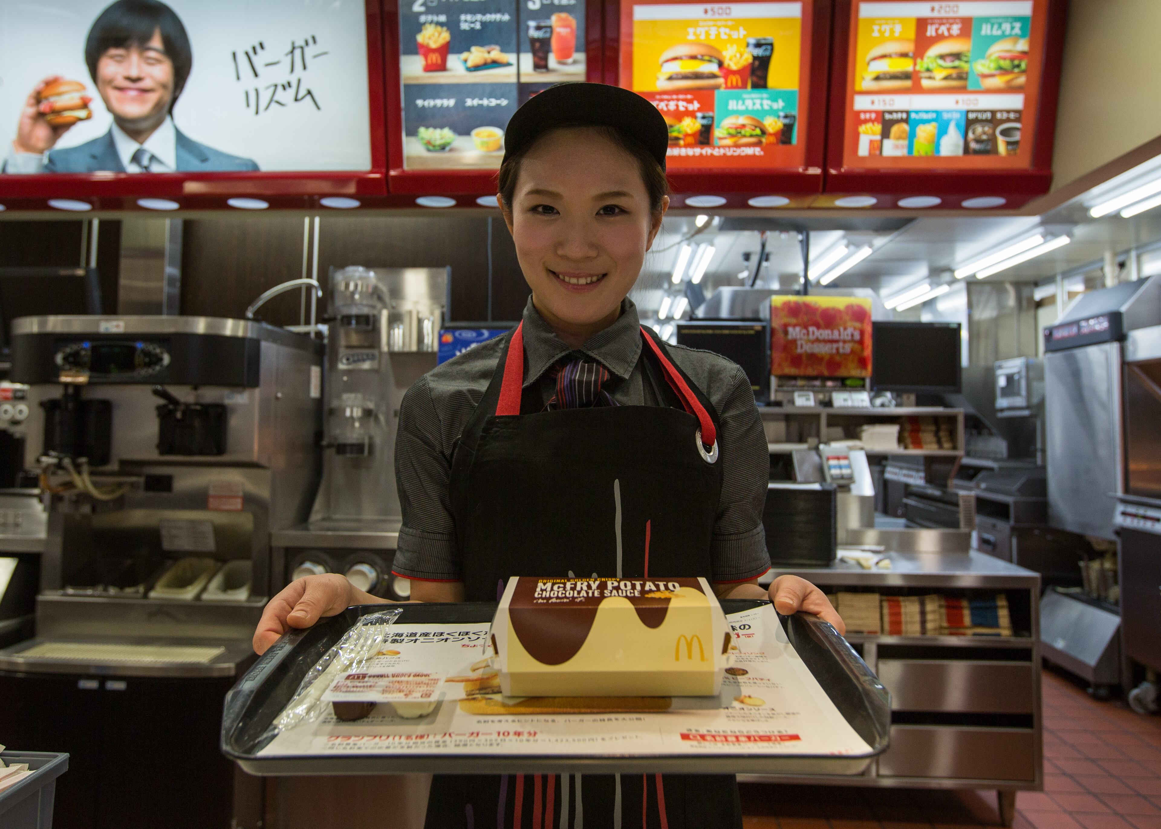 TOKYO, JAPAN - JANUARY 25: McDonald's Japan Swing Manager Miwa Suzuki presents a box of McChoco Potato on January 25, 2016 in Tokyo, Japan. The McChoco Potato, McDonald's Japan's special winter menu, french fries covered in chocolate and white chocolate sauces will be available in McDonald's restaurants on January 26, 2016 until around mid February. (Photo by Christopher Jue/Getty Images)