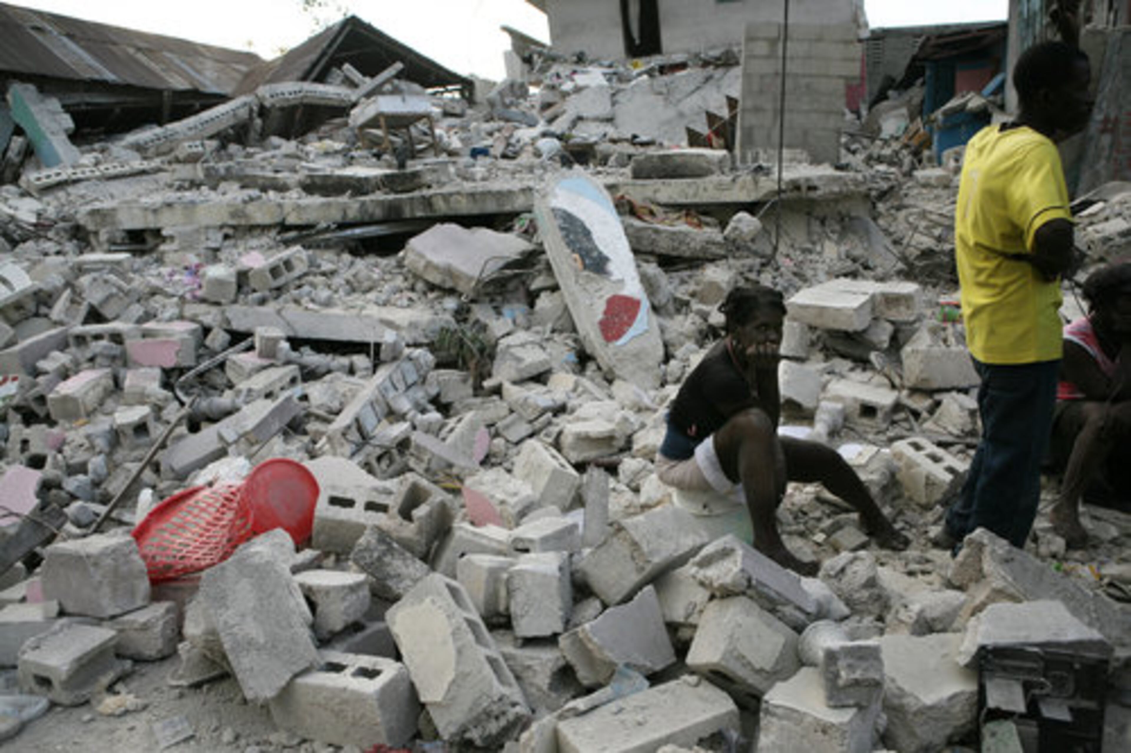 A young woman sits surrounded by rubble and debris in Port-au-Prince, Haiti, on Wednesday, Jan. 13, 2010. Huge swaths of Port-au-Prince lay in ruins, and thousands of people were feared dead in the rubble of government buildings, foreign aid headquarters and shantytowns that collapsed a day earlier in a powerful earthquake.