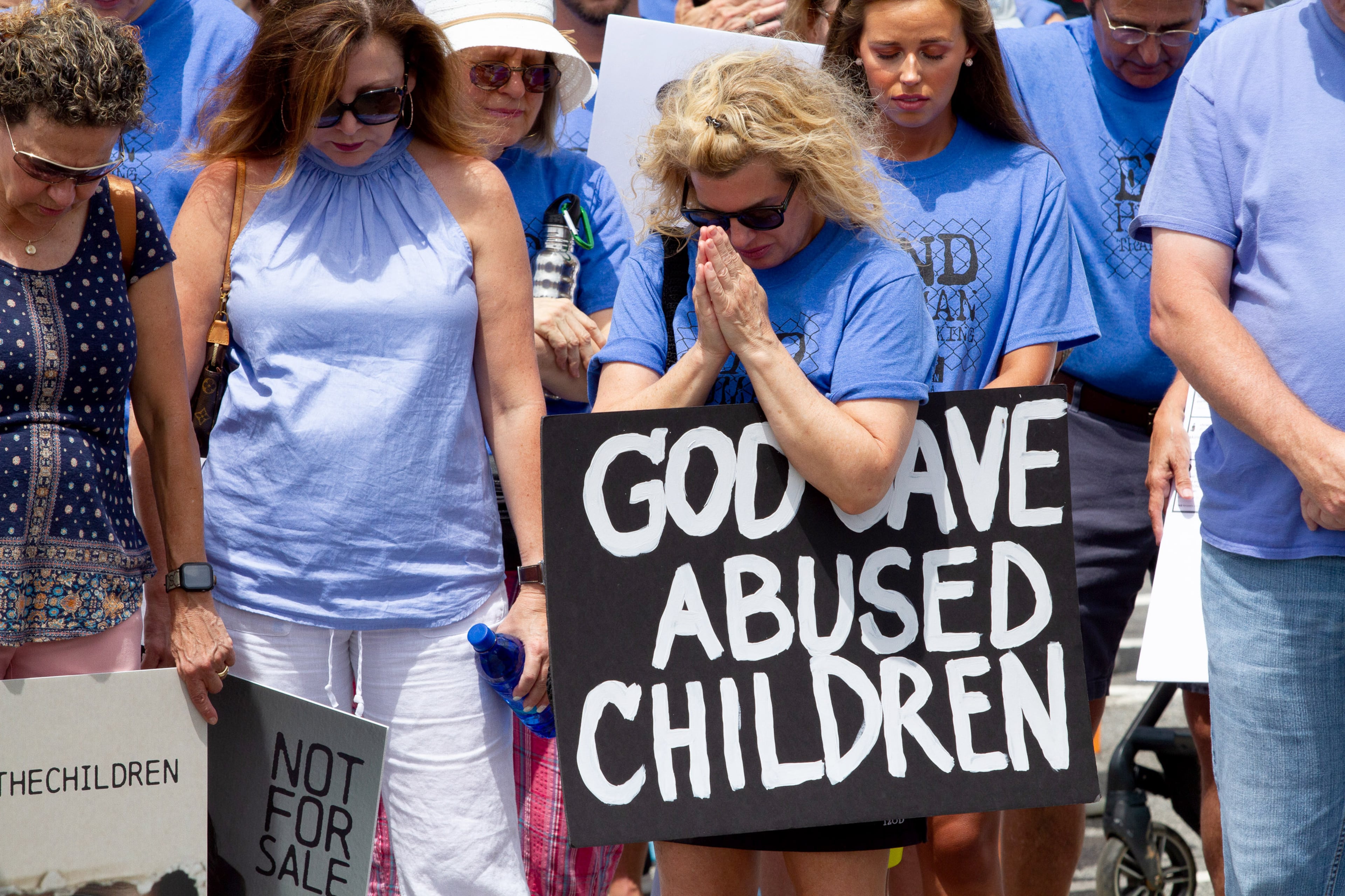 Standing with the Children protesters take a moment to pray at Woodstock Elementary before heading to the Elm Street Event Green in Woodstock Saturday, August 22, 2020. STEVE SCHAEFER FOR THE ATLANTA JOURNAL-CONSTITUTION