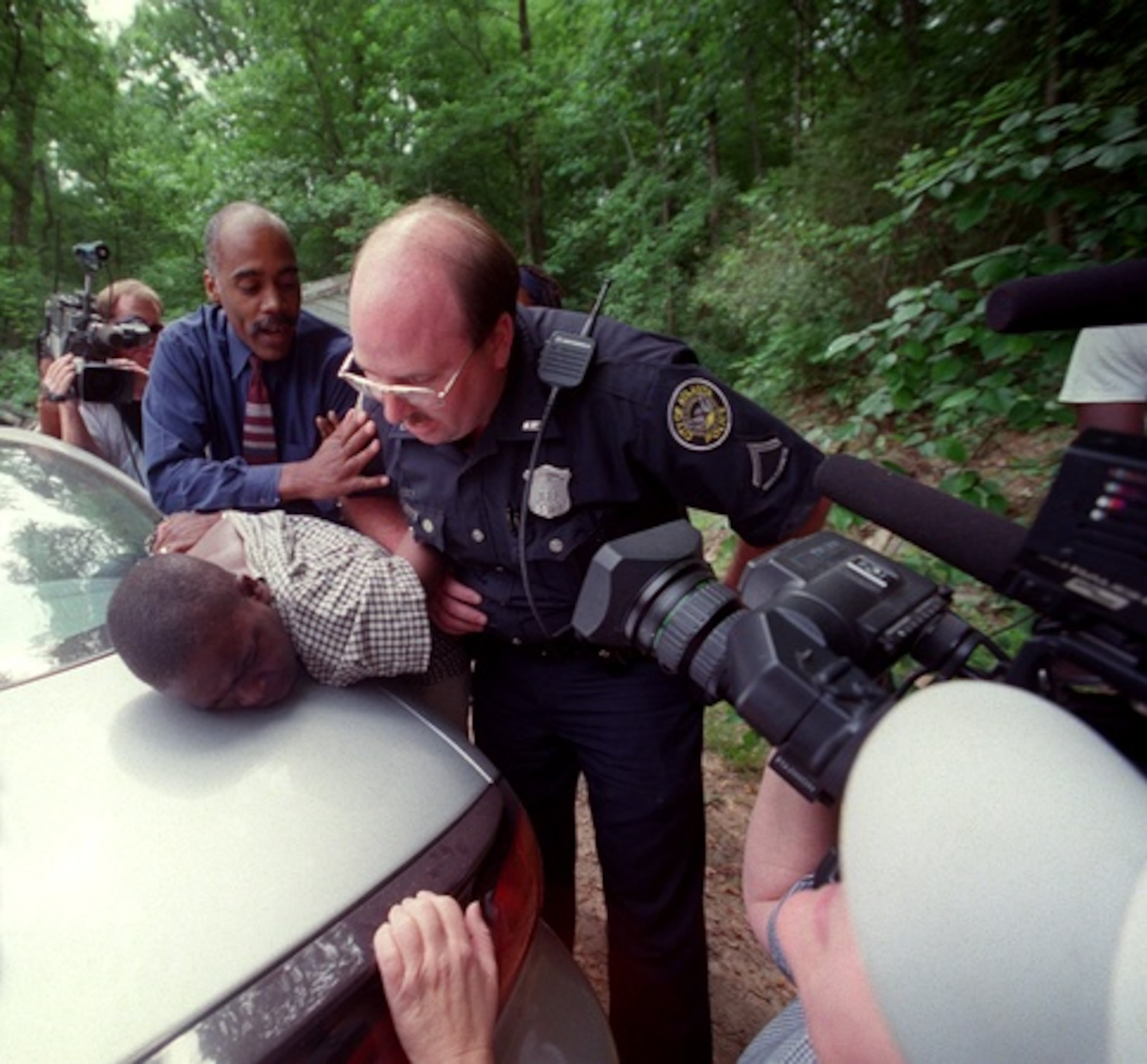 In 2001, state officials sought to remove children from House of Prayer parents after some of the children showed up in school with welts and bruises from whippings. Quinton Frazier, 12, has his head put down onto the trunk lid of a car as DFACS and Atlanta police officials take him into custody from his family's Atlanta home. (KIMBERLY SMITH/FILE)