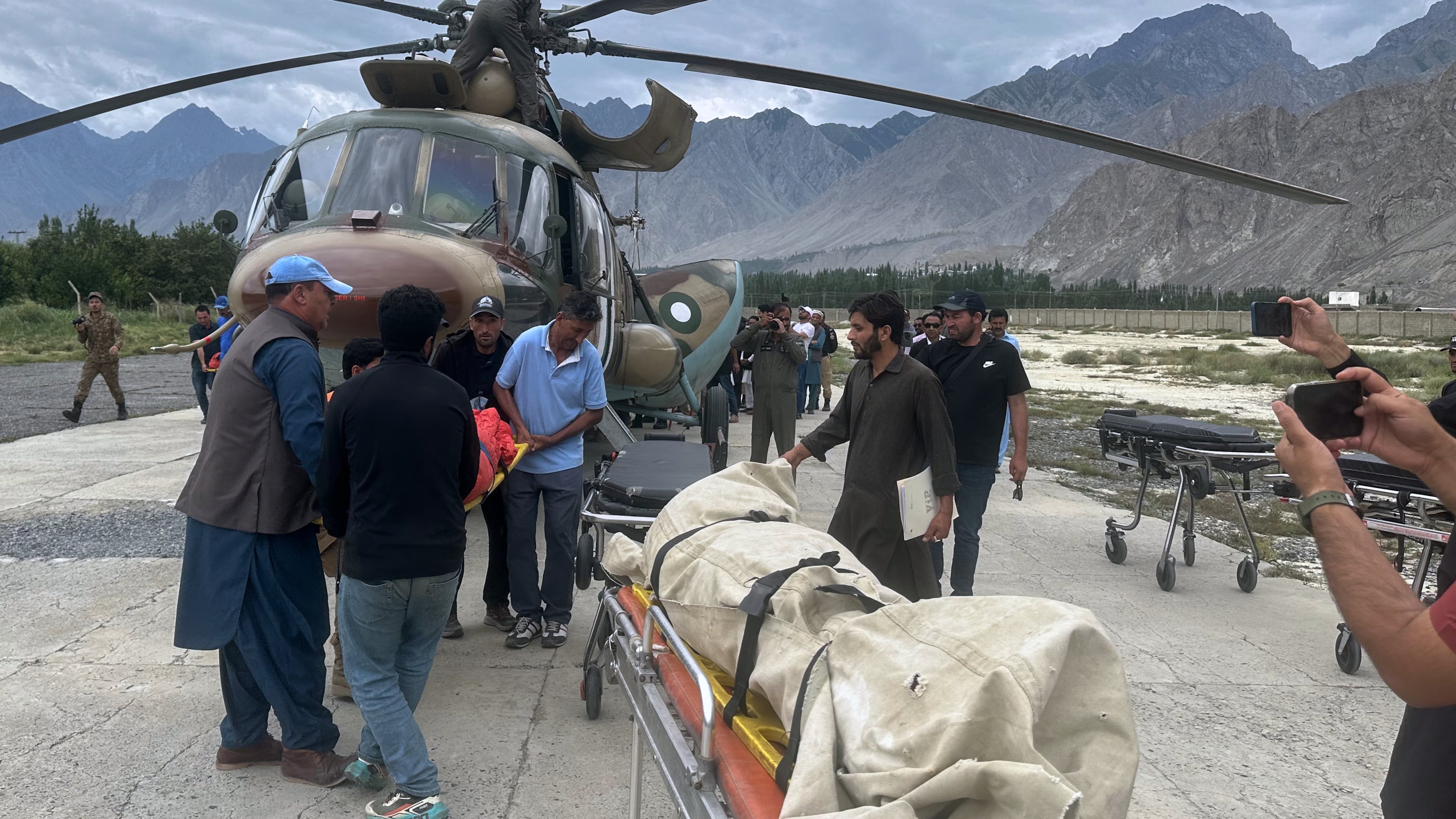 Pakistani army soldiers and volunteers unload from a helicopter the bodies of climbers, that were recovered from Broad Peak nearly a week after an avalanche swept away a 10-member international expedition, upon arrival at a military base in Skardu, in northern Pakistan, Thursday, Aug. 6, 2026. (AP Photo/ M.H. Balti)