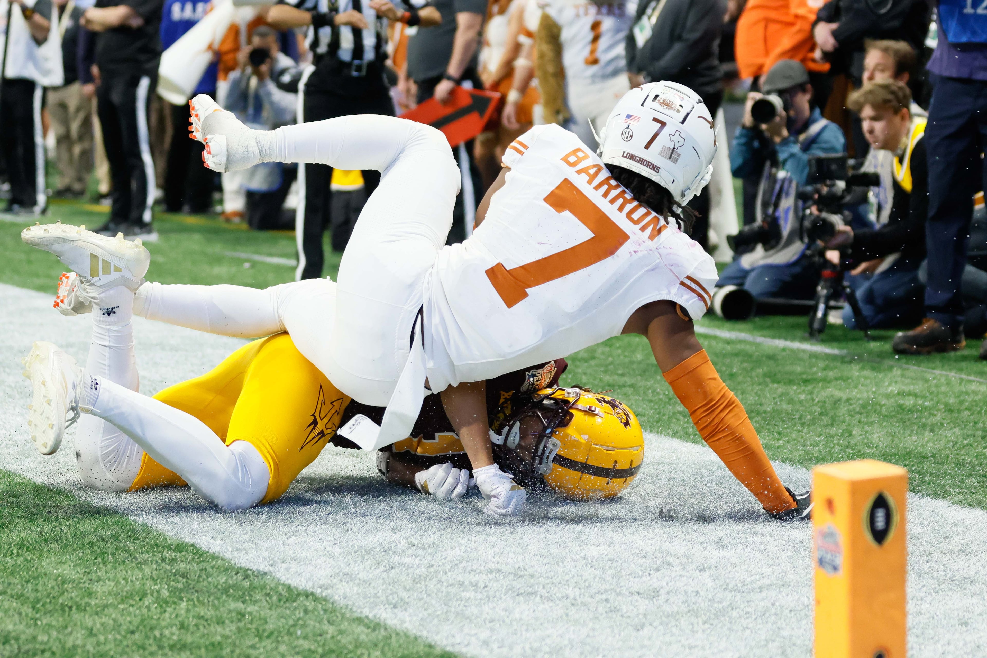 Texas Longhorns defensive back Jahdae Barron (7) landed on top of Arizona State Sun Devils wide receiver Xavier Guillory (1) during the second half in the 2025 Chick-fil-A Peach Bowl at Mercedes-Benz Stadium, Wednesday, January 1, 2025, in Atlanta.
(Miguel Martinez / AJC)