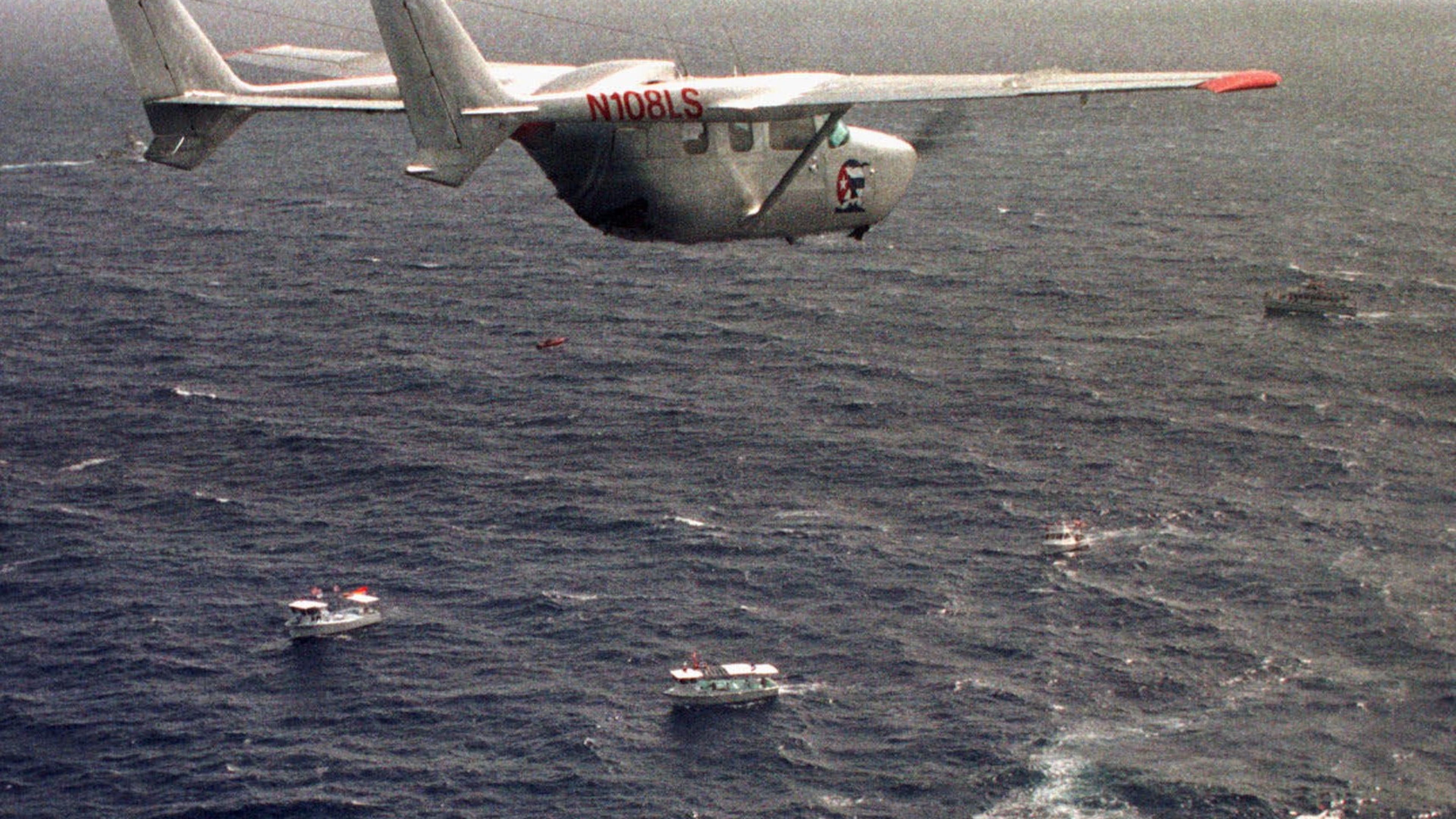 FILE - A Brothers to the Rescue plane flies over The Democracy Movement flotilla at the twelve-mile limit north of Havana, Cuba, July 10, 1999. (AP Photo/Alan Diaz, File)