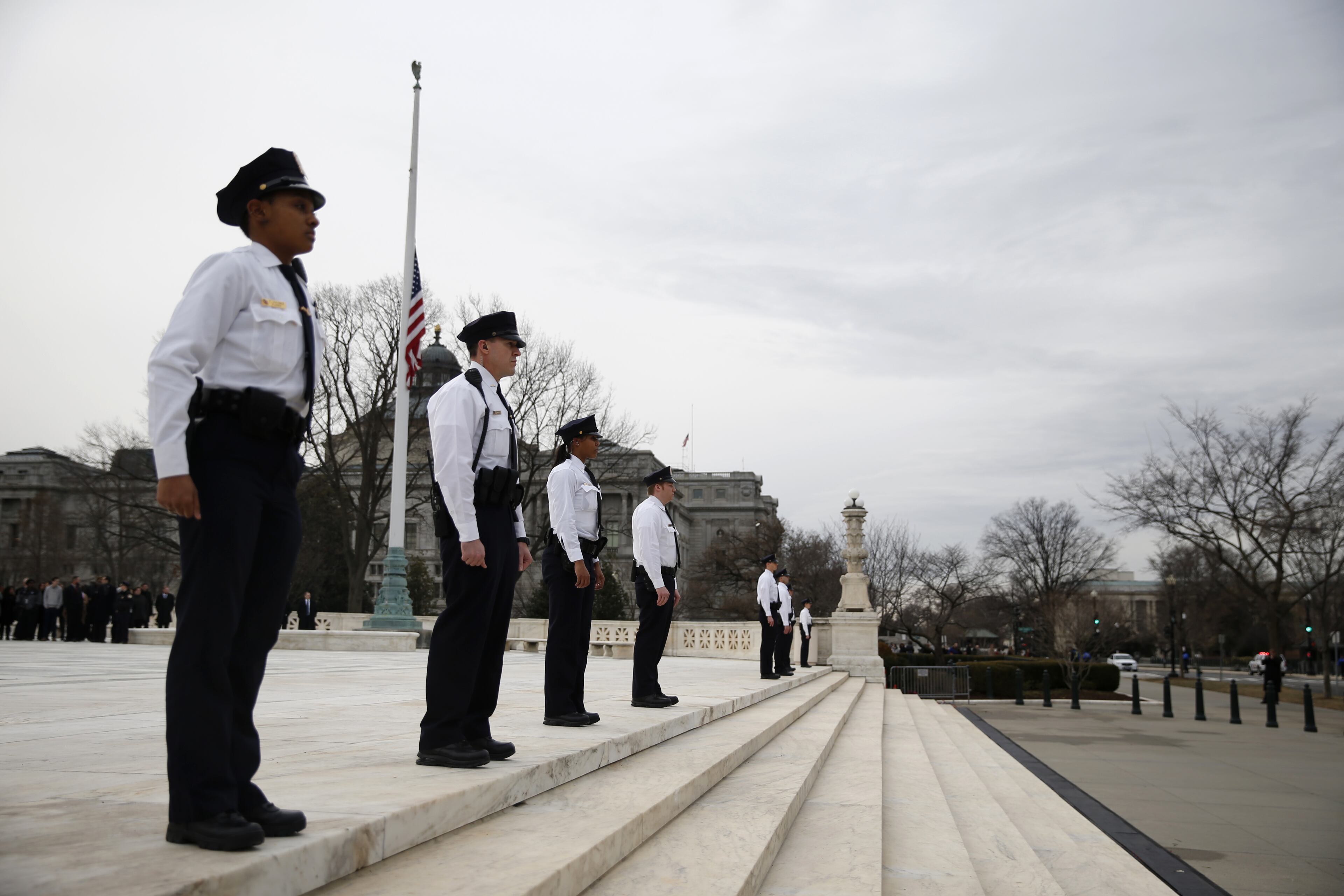 Supreme Court police officers stand on the steps of the court in Washington, Friday, Feb. 19, 2016, awaiting the arrival of the late Justice Antonin Scalia. Thousands of mourners will pay their respects Scalia as his casket rests in the Great Hall of the Supreme Court, where he spent nearly three decades as one of its most influential members. (AP Photo/Evan Vucci)