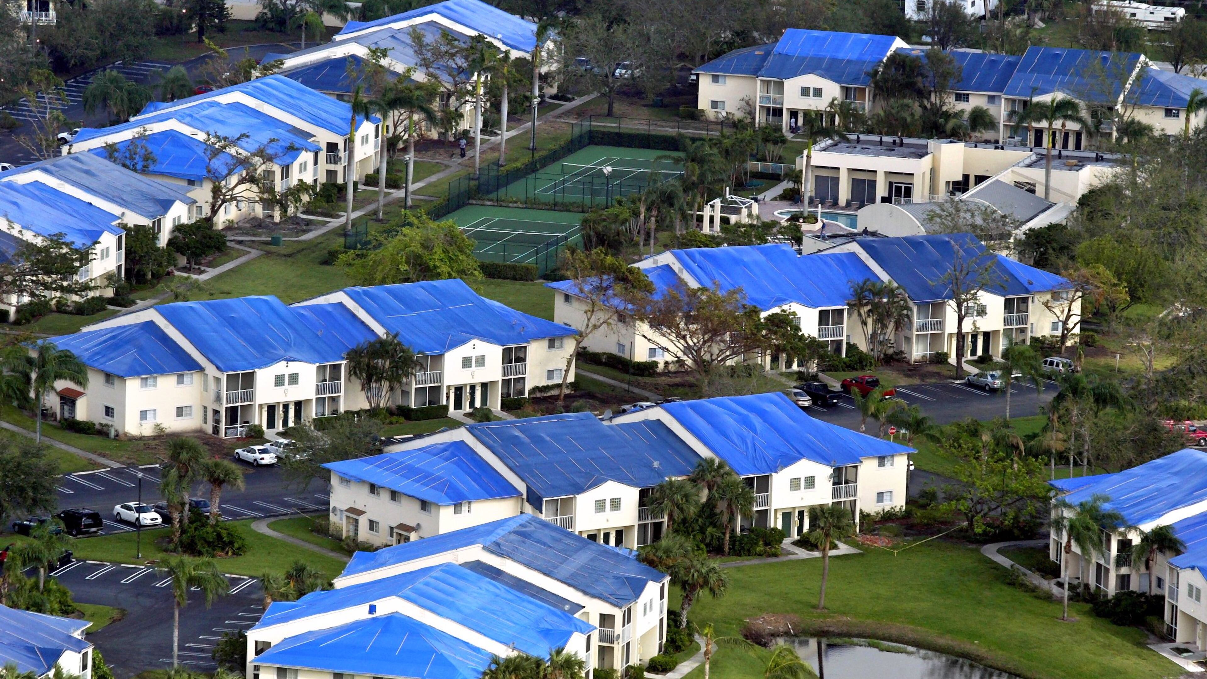 Blue tarps covering storm-damaged roofs in West Palm Beach after a prior storm. (Lannis Waters/ The Palm Beach Post)