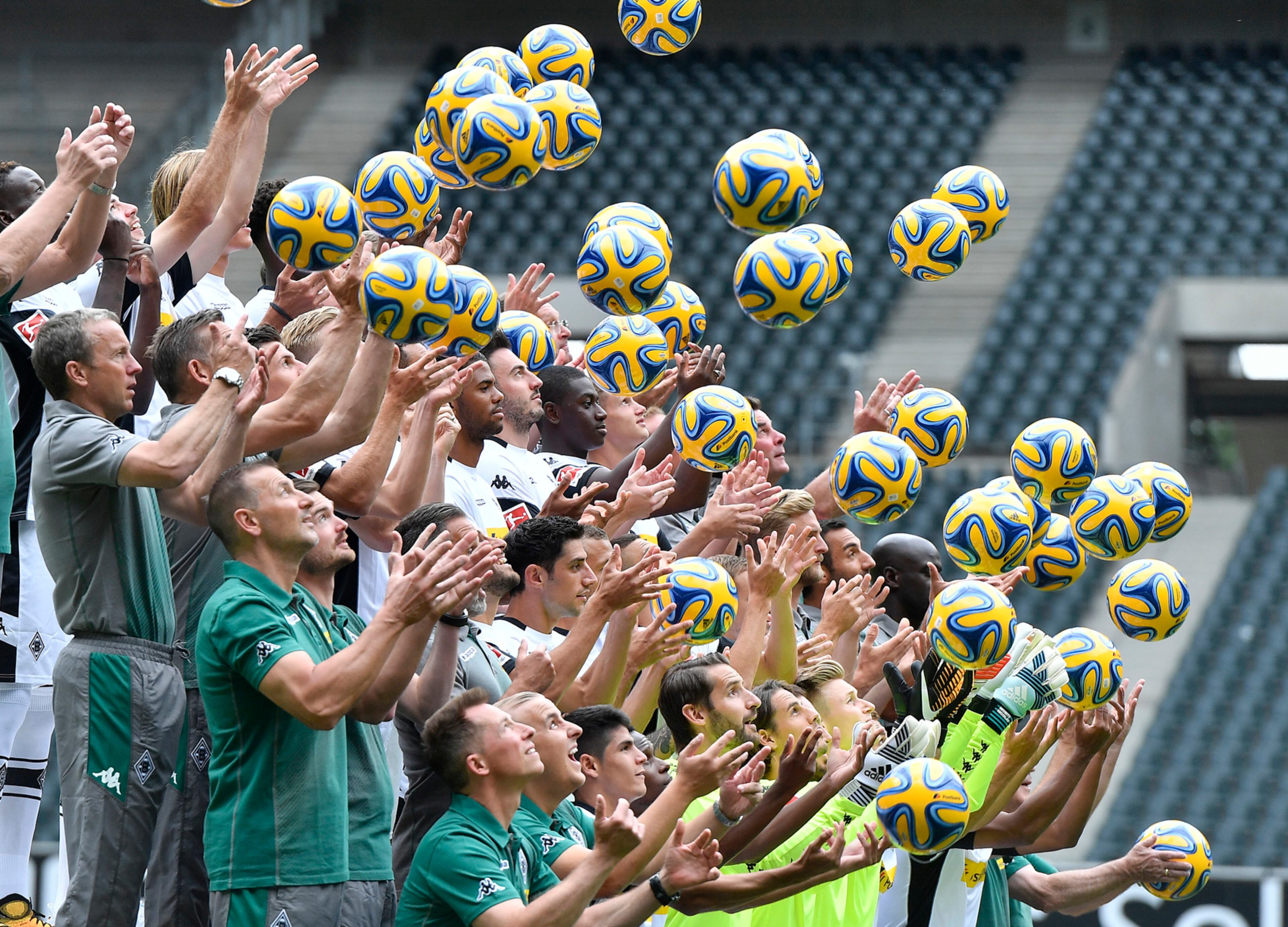 Players and team members of Bundesliga soccer club Borussia Moenchengladbach throw and catch balls during a photo session for the new Bundesliga season at the Borussia Park in Moenchengladbach, Germany, Friday, July 28, 2017. (AP Photo/Martin Meissner)