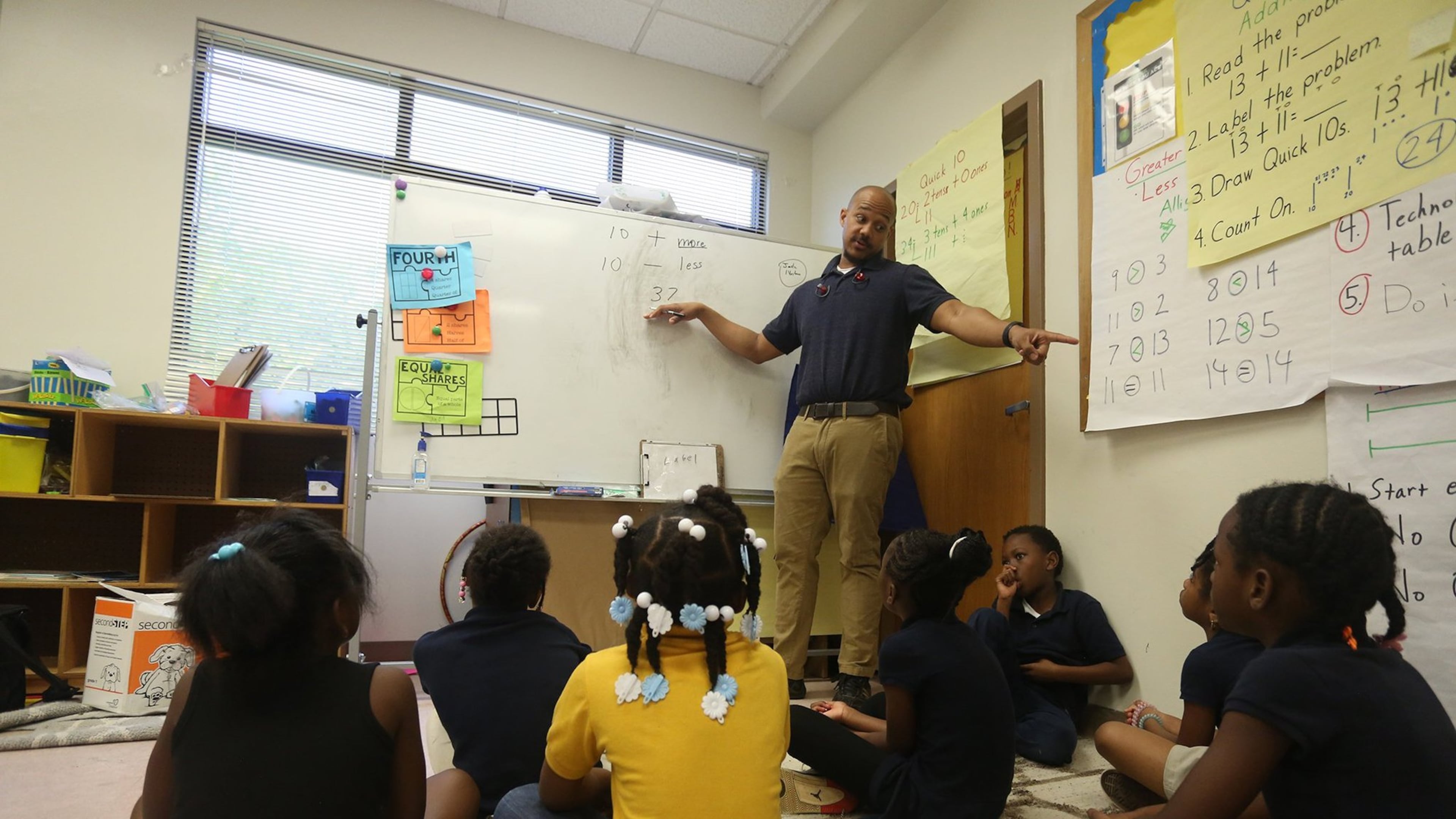 First grade teacher Malcolm Davis teaches his students basic math skills.