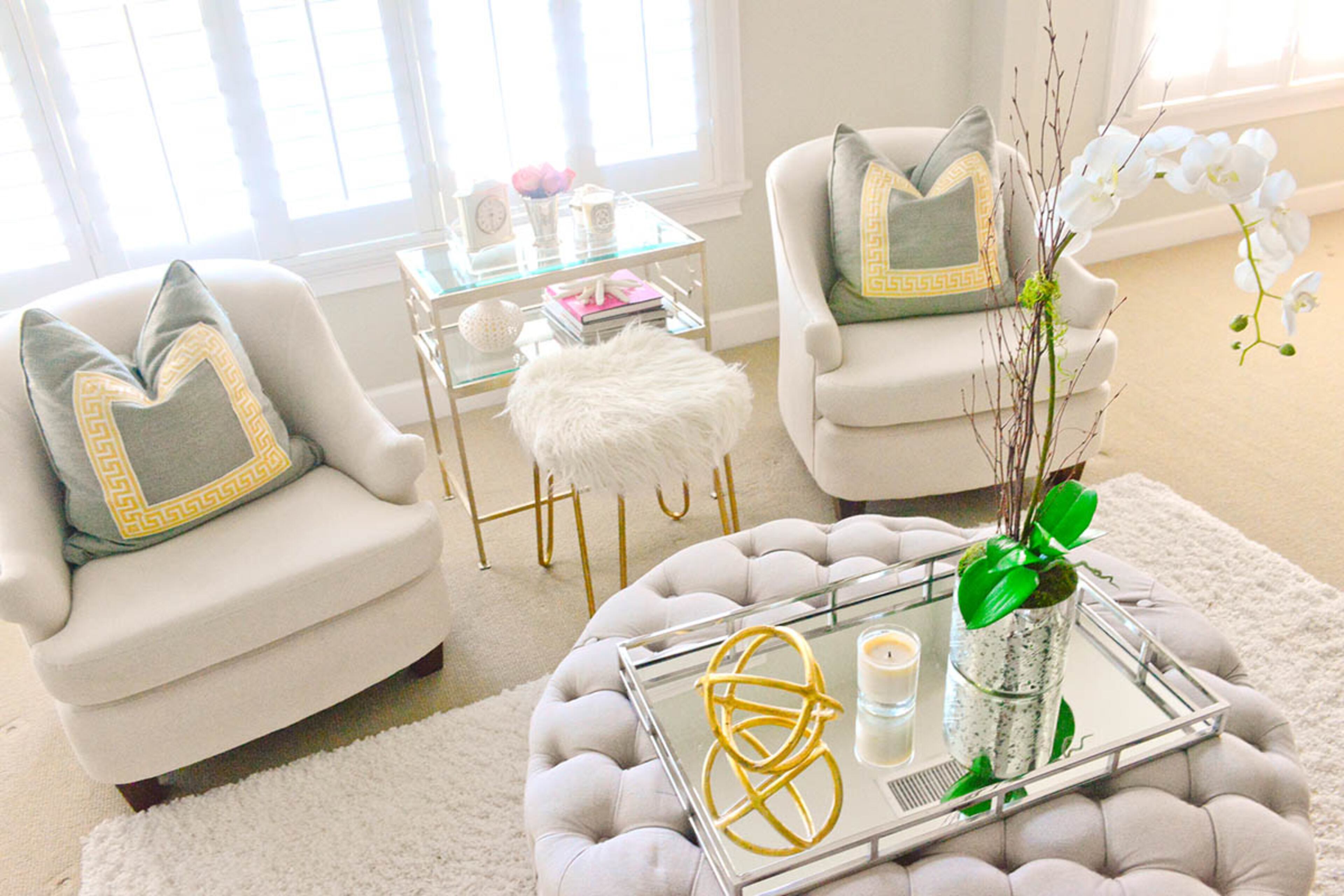 Muted colors fill the master bedroom, giving it a serene appeal. Gold accents the neutral palette. A comfortable sitting area with chairs from Scott Antique Markets gives the homeownersa private retreat.