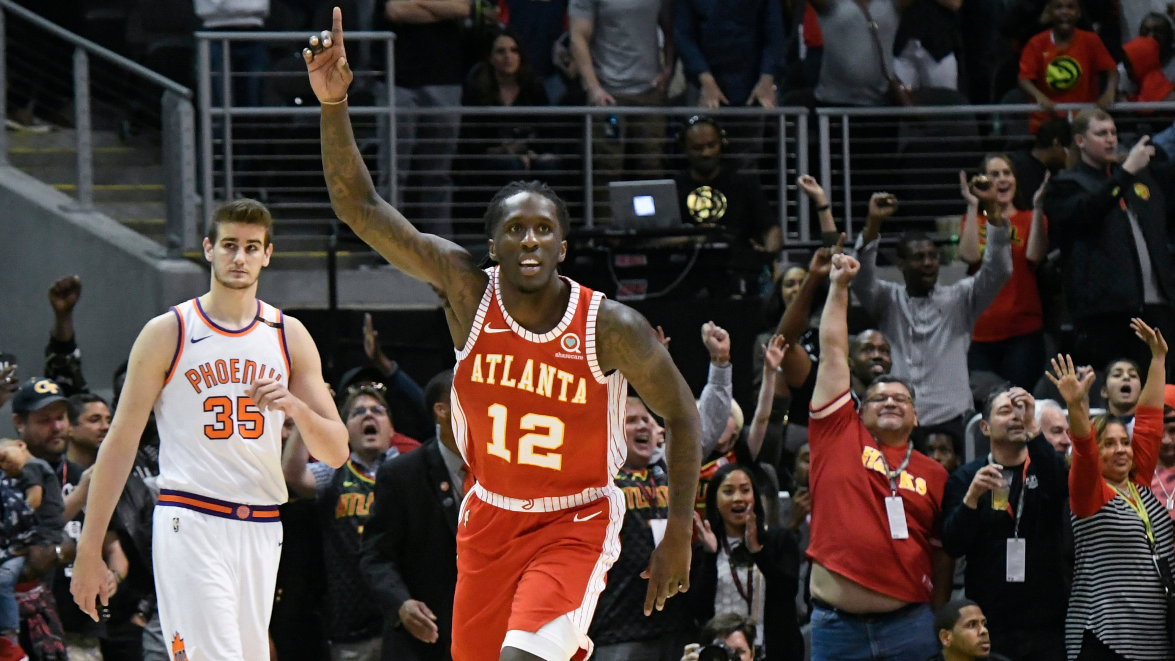 Atlanta Hawks forward Taurean Prince (12) reacts as Phoenix Suns forward Dragan Bender (35) looks on as an NBA basketball game comes to an end Sunday, March 4, 2018, in Atlanta. (AP Photo/John Amis)