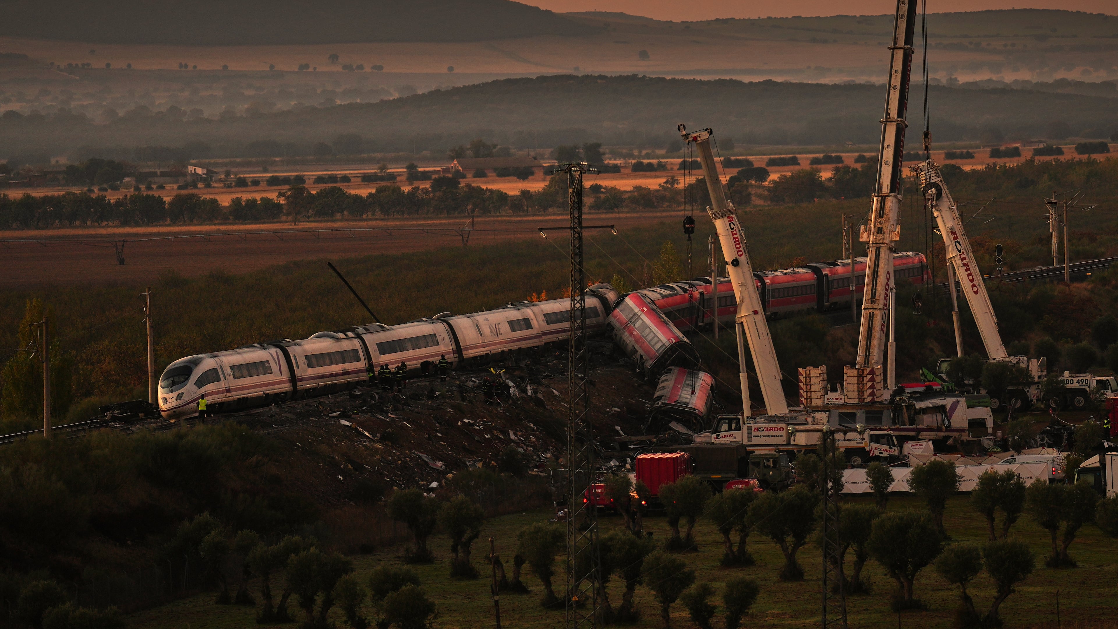 Cranes lift wrecked train carriages as rescuers search for victims following a collision between two trains in Urda, Spain, Thursday, Oct. 29, 2026. (AP Photo/Manu Fernandez)