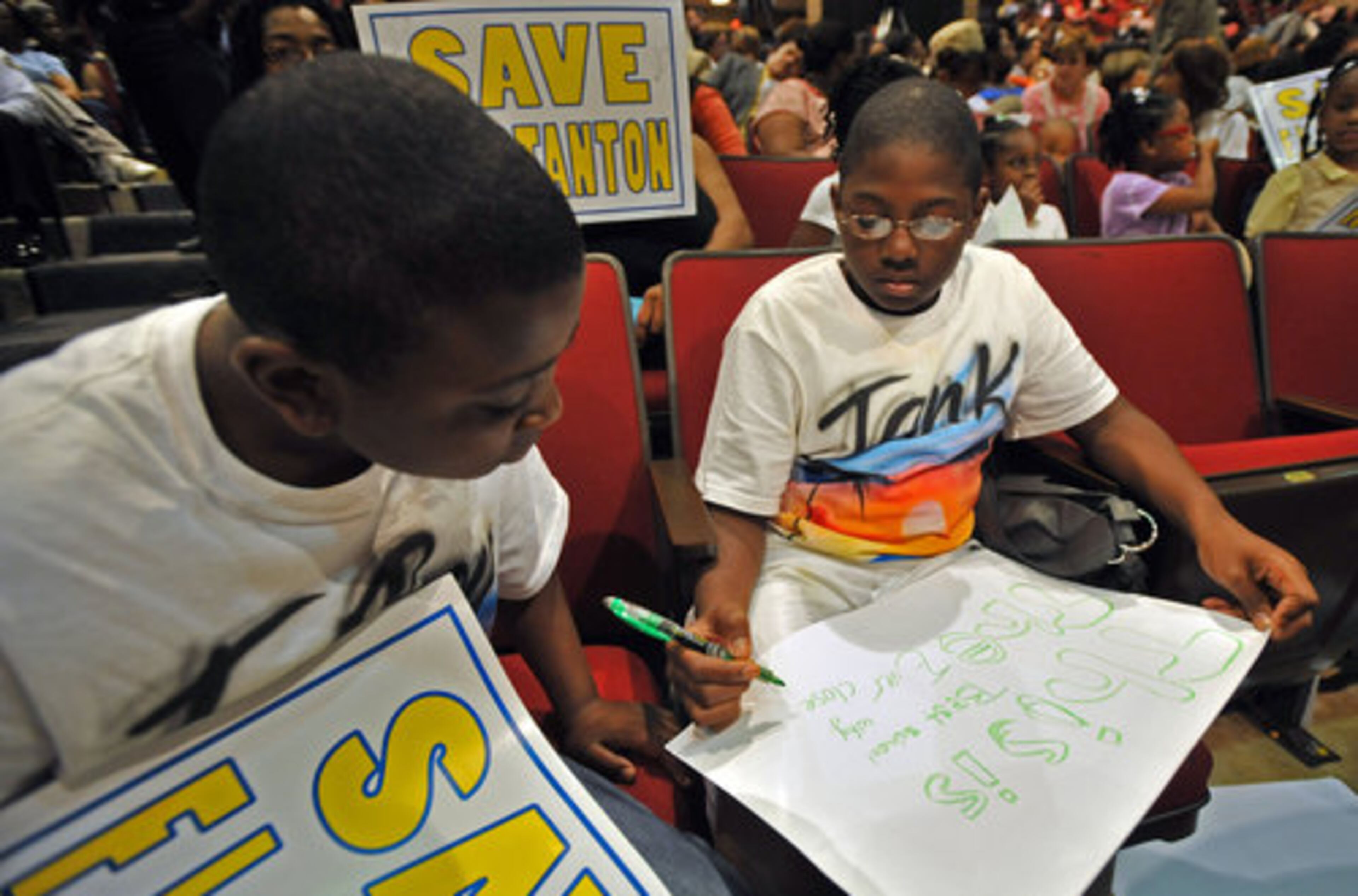 Keenan Cooper Jr. (left), 10, and his brother, Demetrius Marshall, 12, who both go to F. L. Stanton Elementary School, make signs to support their school.
