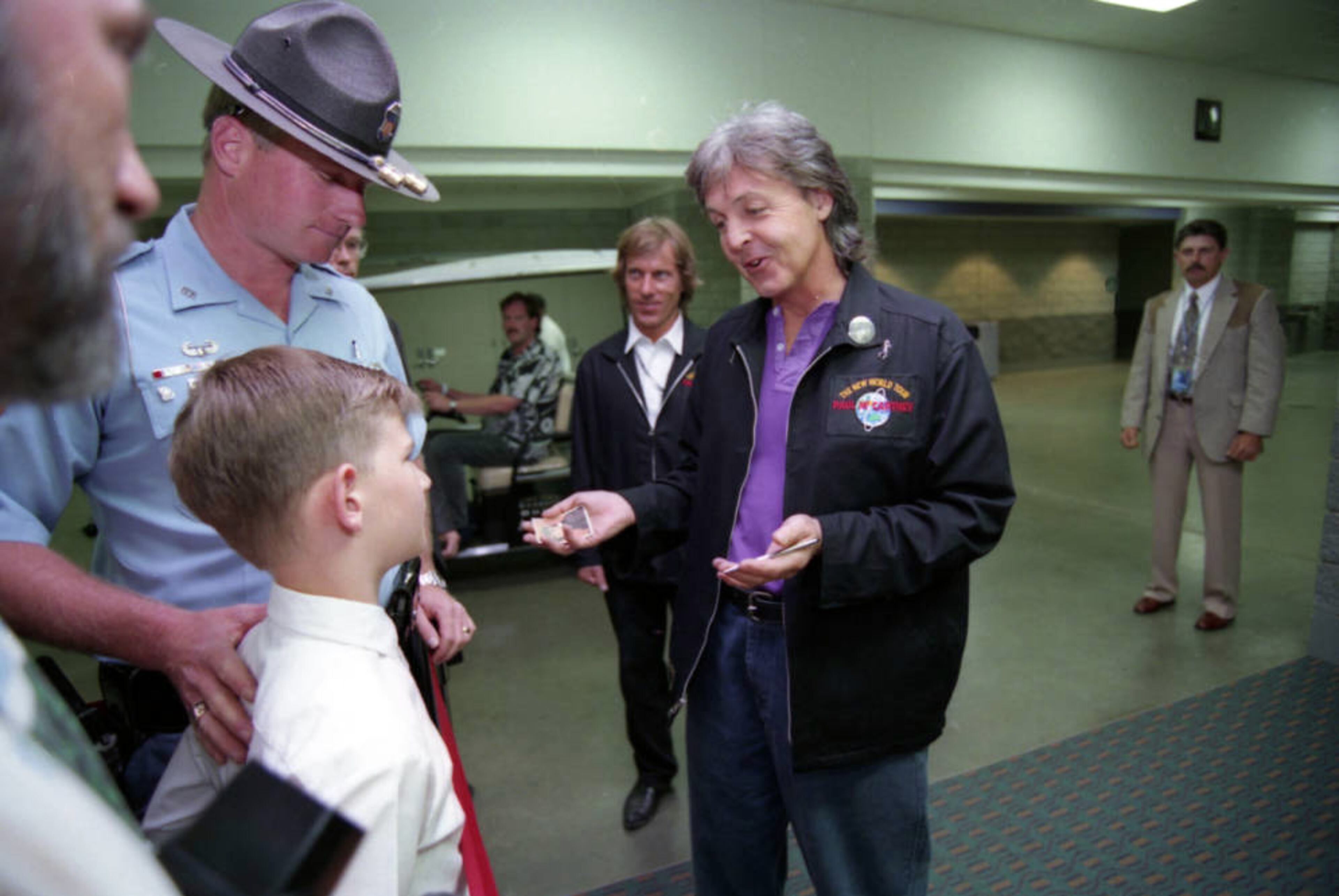 Paul McCartney gives an autographerd 'Beatles Diary Card' to 10-year old Bill Keller as his dad, Georgai State Patrol trooper Van Keller, looks on just before McCartney's May 1, 1993, concert at the Georgia Dome.