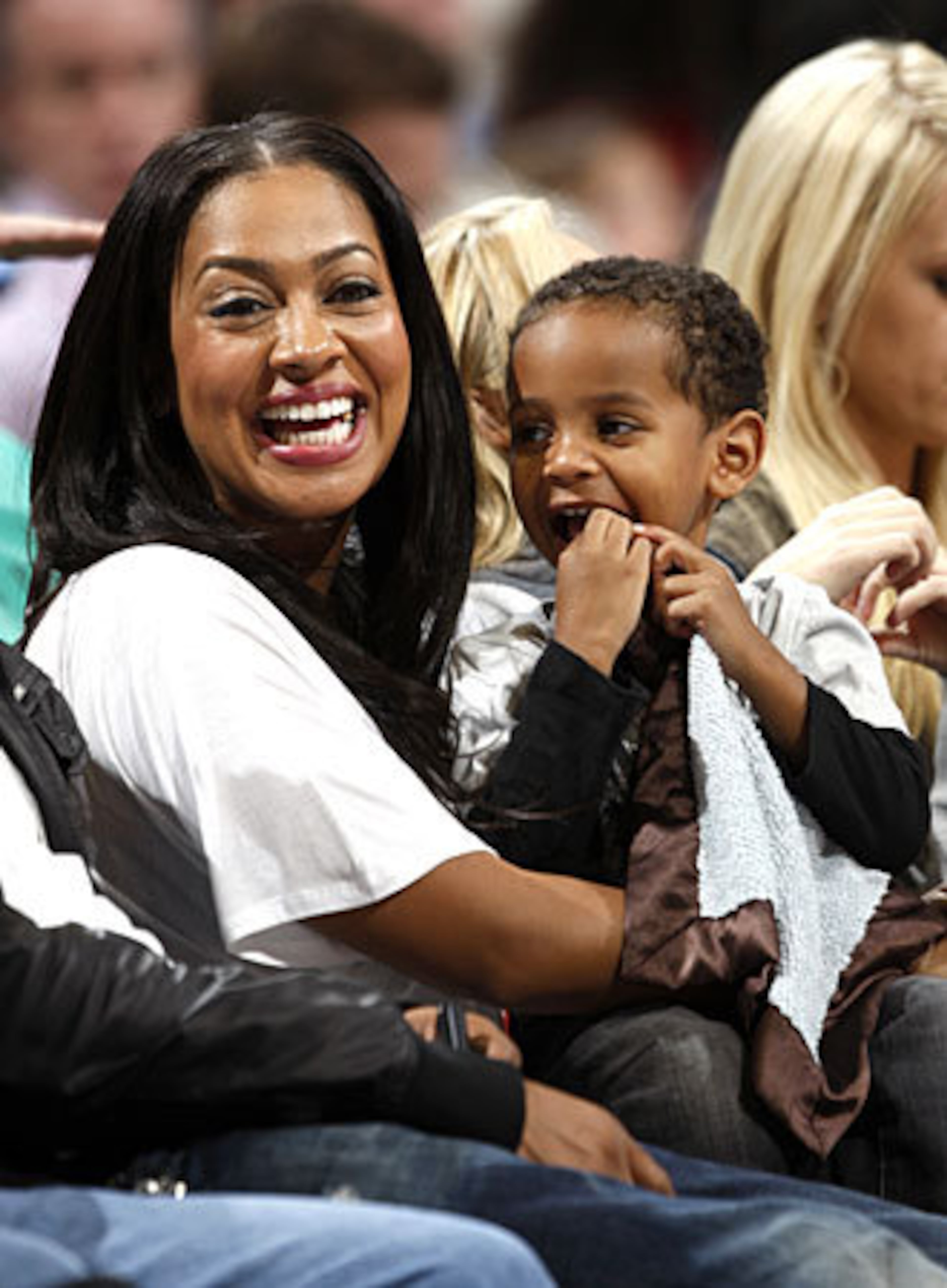 Cable television show emcee La La Vazquez (left) laughs while holding her son, Kiyan Anthony, as they watch the Denver Nuggets' 112-93 victory over the Chicago Bulls in an NBA basketball game in Denver on Saturday, Nov. 21, 2009. Vazquez is the finace of Nuggets forward Carmelo Anthony.