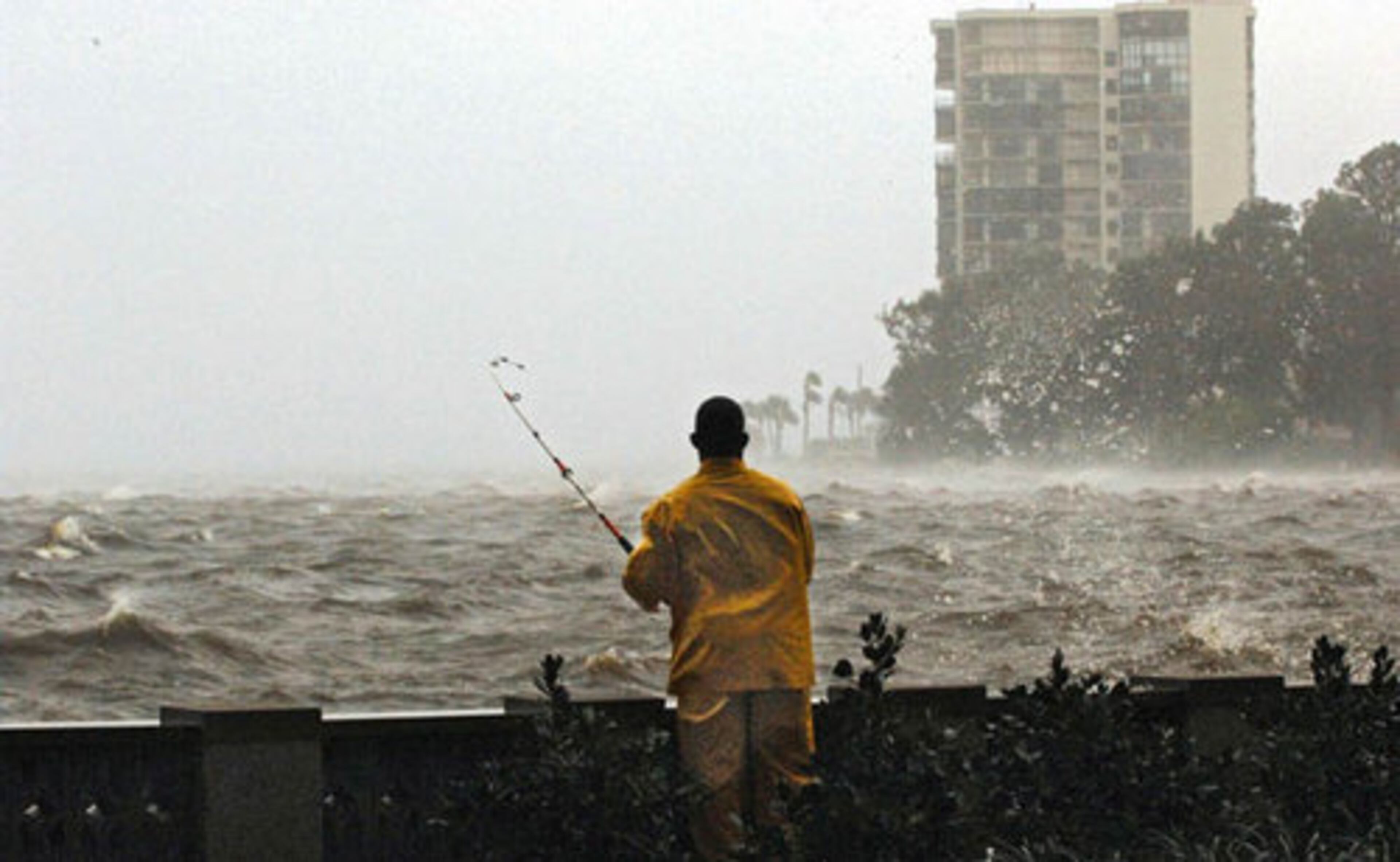 Eric Edwards fishes along the sea wall under the Fuller Warren Bridge and the Northbank Riverwalk, Friday in Jacksonville, Fla.