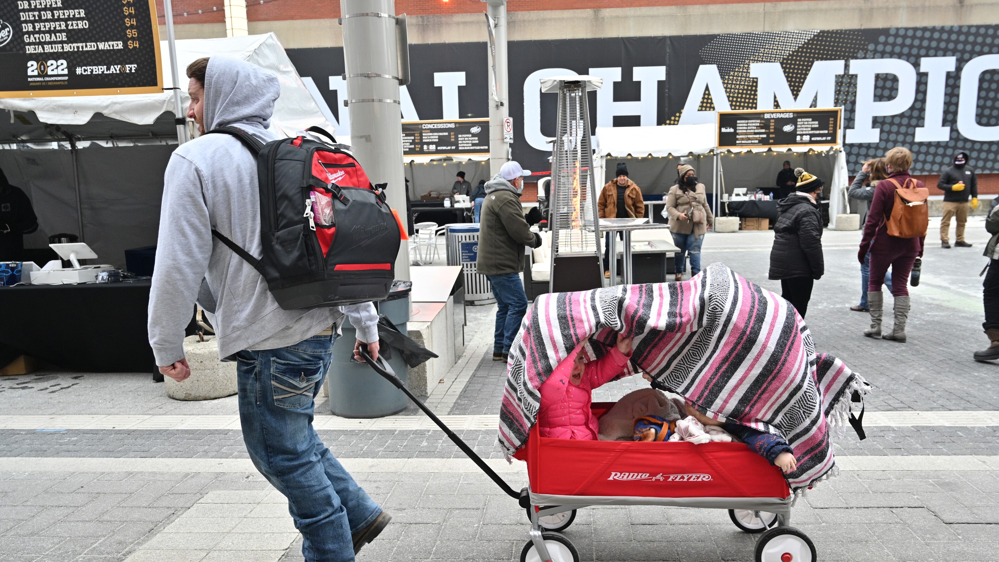 January 8, 2022 Indianapolis, IN - Young football fans bundle up on Georgia Street in downtown Indianapolis on Saturday, January 8, 2022. 2022 College Football Playoff National Championship culminates in a weekend of events as downtown Indianapolis transforms into Championship Campus. Festival of attractions and activities starting Saturday, January 8 through Monday, January 10. (Hyosub Shin / Hyosub.Shin@ajc.com)