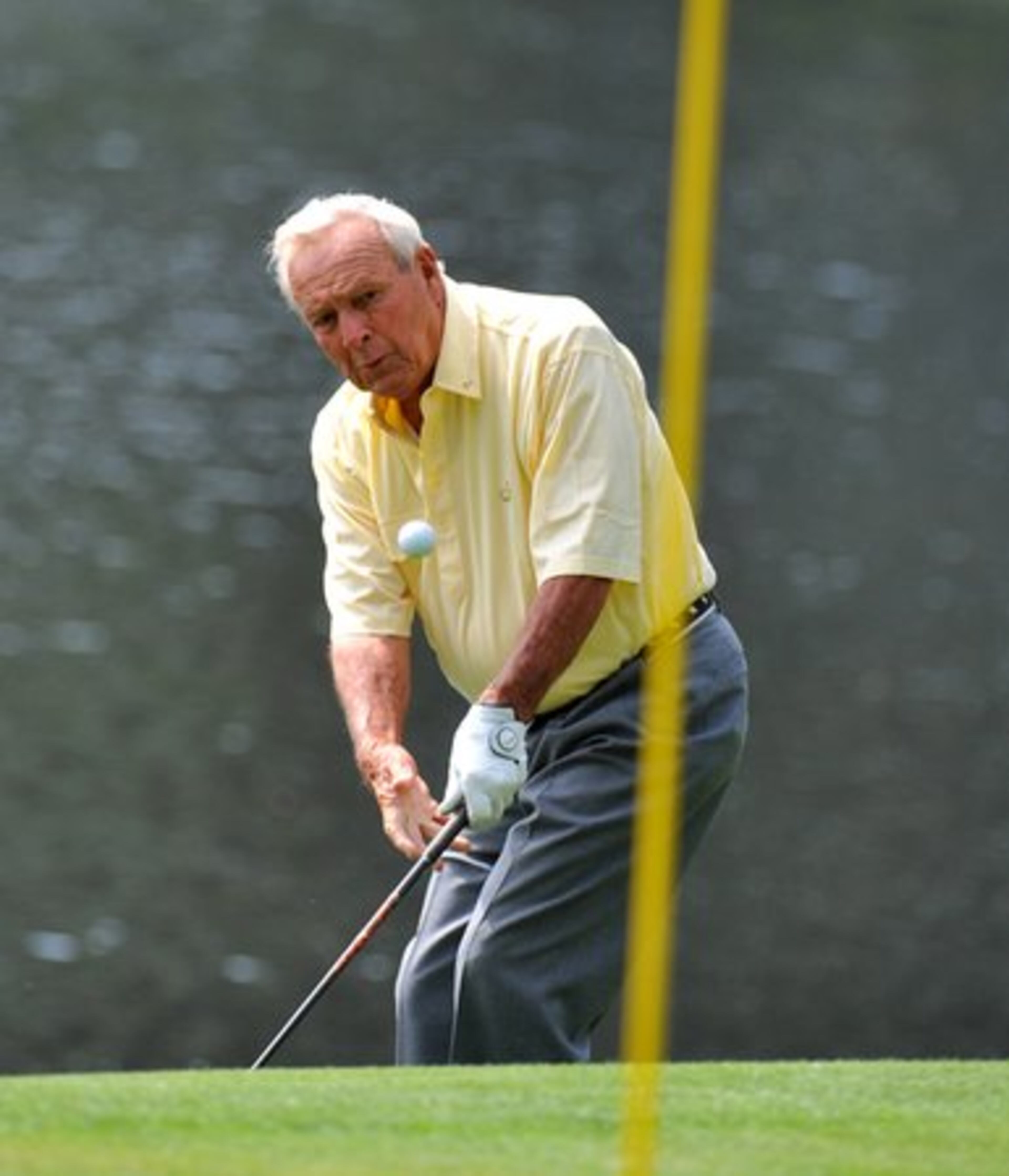 Four time Masters champion Arnold Palmer chips onto the green during the par three contest at the Augusta National Wednesday April 7, 2010.