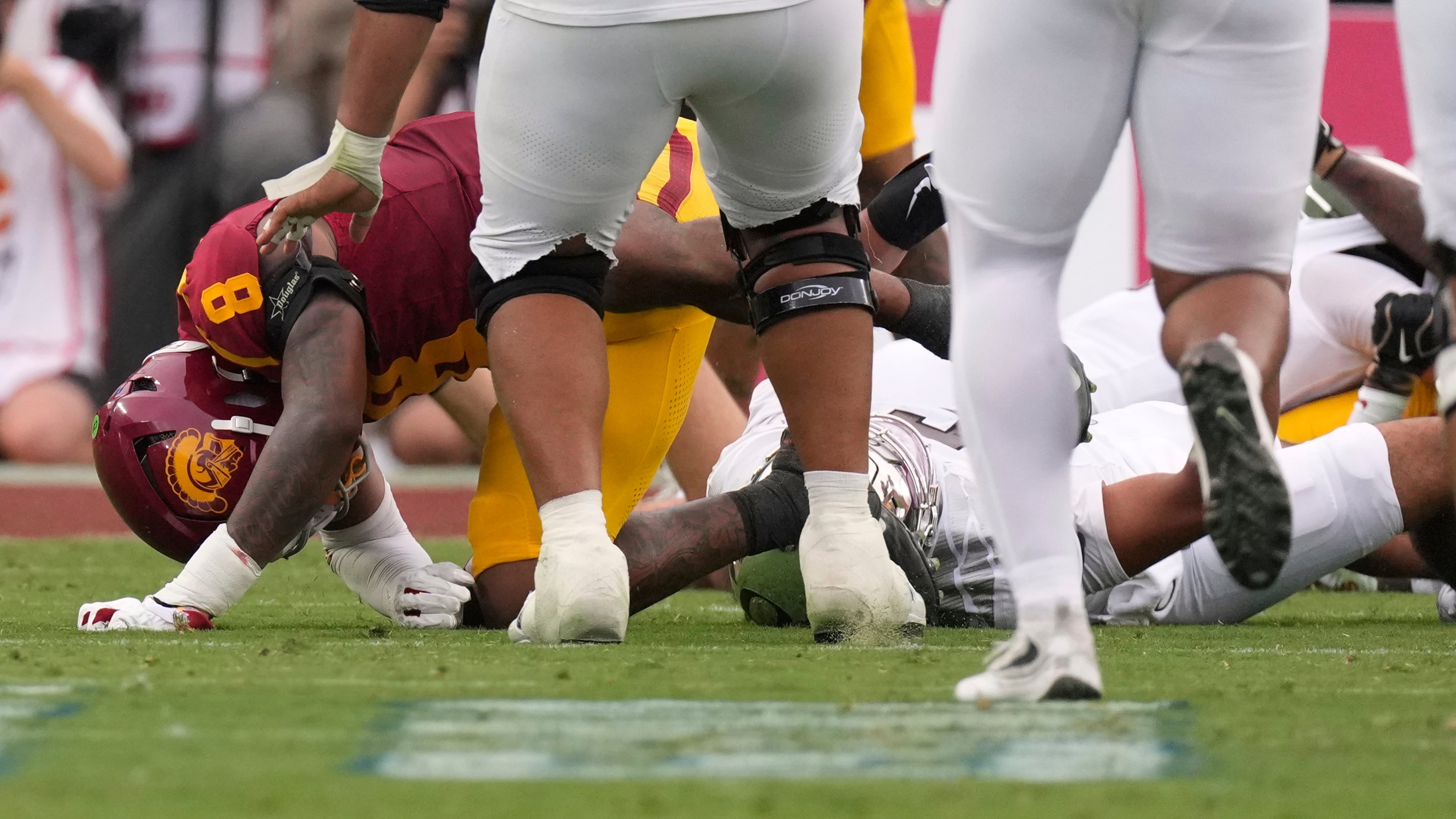 Oregon quarterback Dante Moore, bottom right, takes a hard tackle by Southern California linebacker Desman Stephens II (8) during the first half of an NCAA college football game, Saturday, Sept. 26, 2026, in Los Angeles. (AP Photo/Mark J. Terrill)