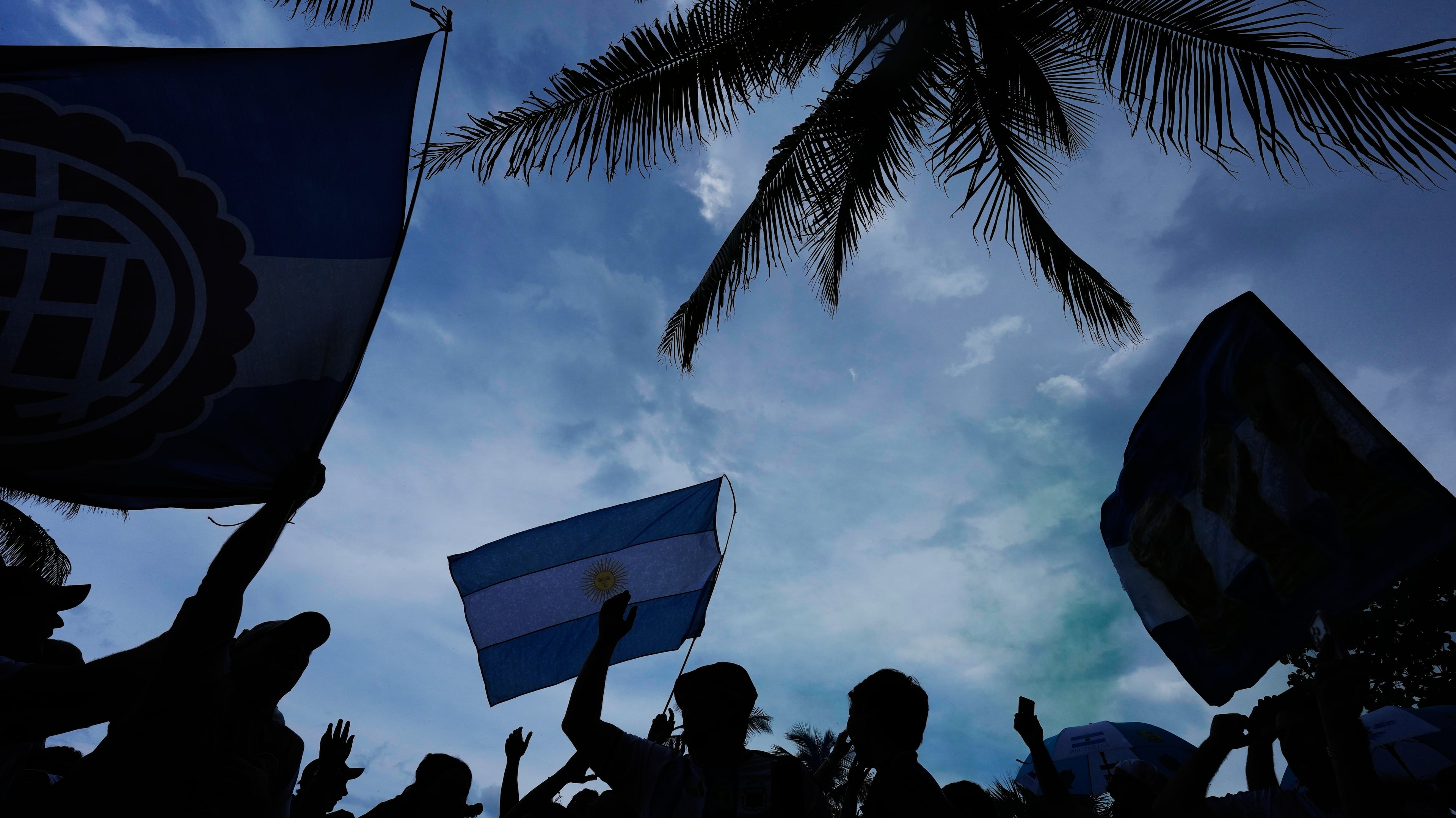 Argentina fans wave flags as they gather to celebrate and cheer on their team at a beachfront park in Miami Beach, Fla., Thursday, July 2, 2026, one day ahead of their World Cup round of 32 soccer match against Cape Verde. (AP Photo/Rebecca Blackwell)