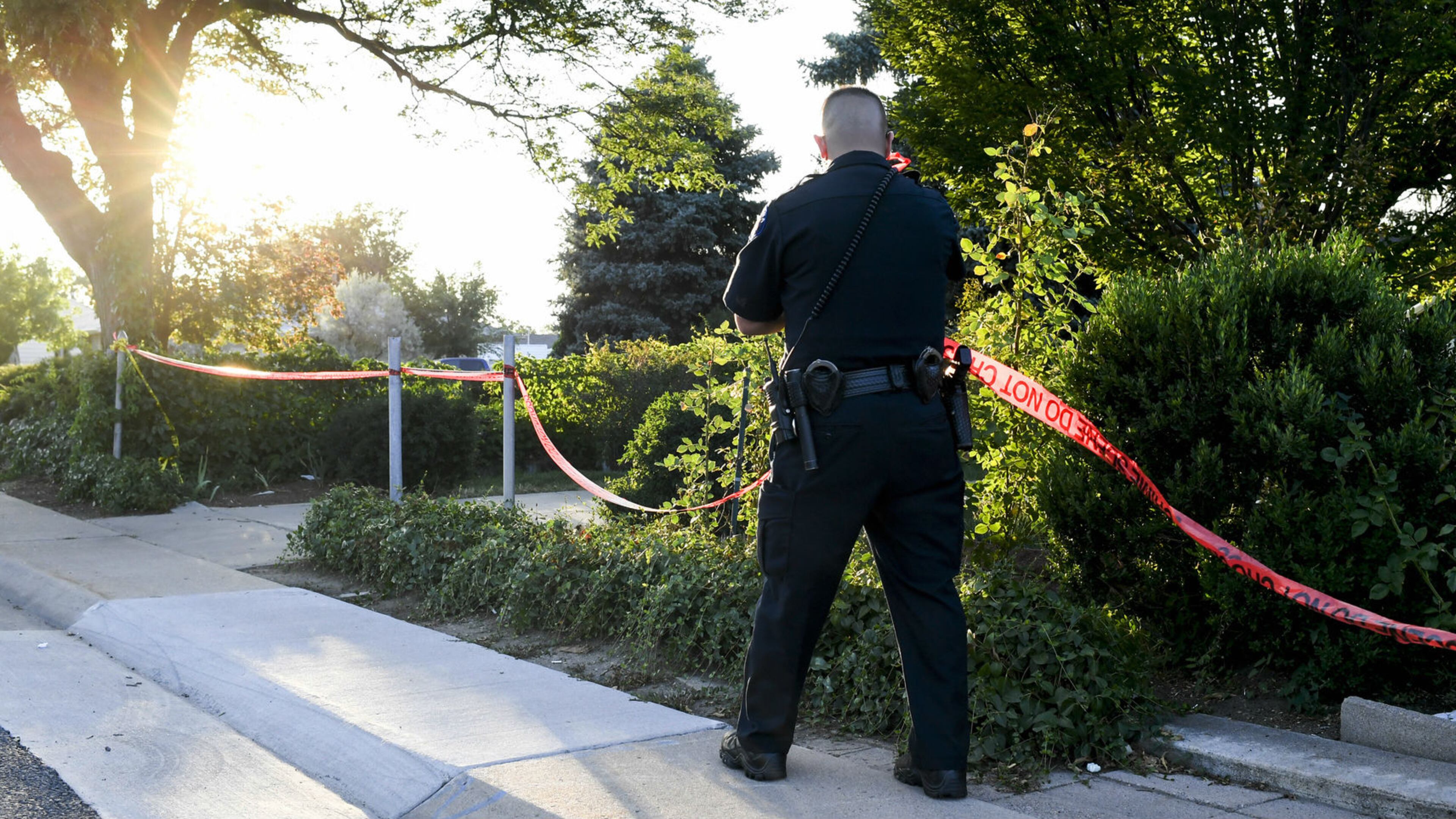 In this July 30, 2018, photo, an Aurora police officer removes crime scene tape from the outside of a home where homeowner Richard "Gary" Black Jr., 73, was shot and killed by police that morning. Black, a Vietnam veteran, was killed moments after killing an intruder who broke into his home and attacked his 11-year-old grandson. The officer who killed Black has been cleared of criminal wrongdoing.