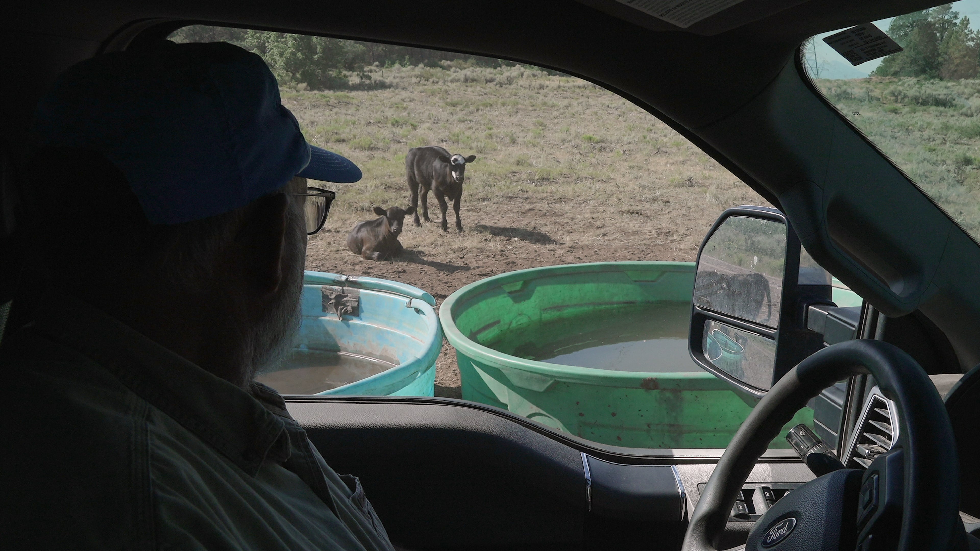 Scott Snyder checks to see how much water his cows have, July 16, 2026 near Montrose, Colo. (AP Photo/Brittany Peterson)